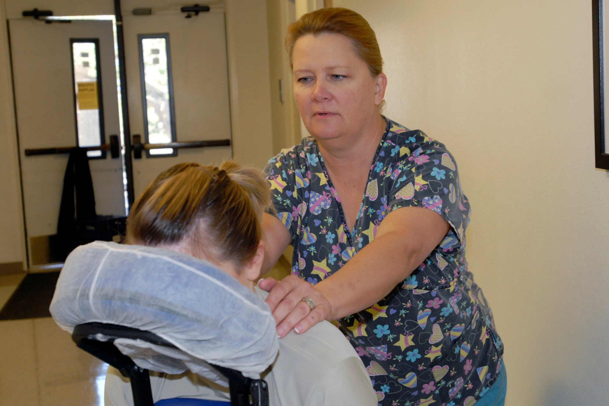 GOODFELLOW AIR FORCE BASE, TEXAS -- Carla Odum provides a massage demonstration to Airman 1st Class Allison Barney, 17th Medical Group, during the Retiree Health Fair Nov. 19. Mrs. Odum, representing Angelo Back and Rehab, participated in the health fair to inform military retirees of one of the services available in the local community. (U.S. Air Force Photo/Lou Czarnecki)