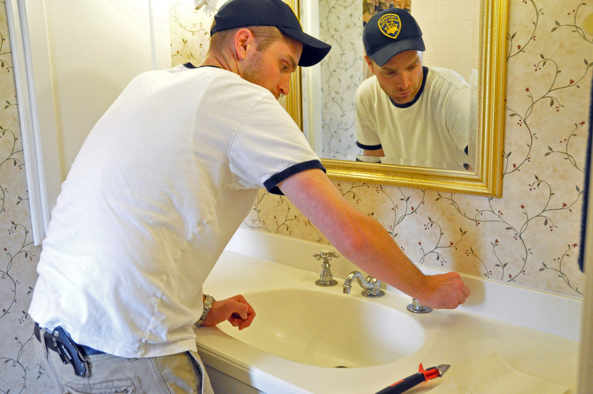 Joshua Henderson, one of 66 volunteers that renovated the Travis Fisher House, re-caulks the bathroom sinks throughout the house Nov. 18. The Fisher House provides a respite for family members of patients staying at David Grant USAF Medical Center, free from financial stress. (U.S. Air Force photo/Airman Madelyn Ottem)