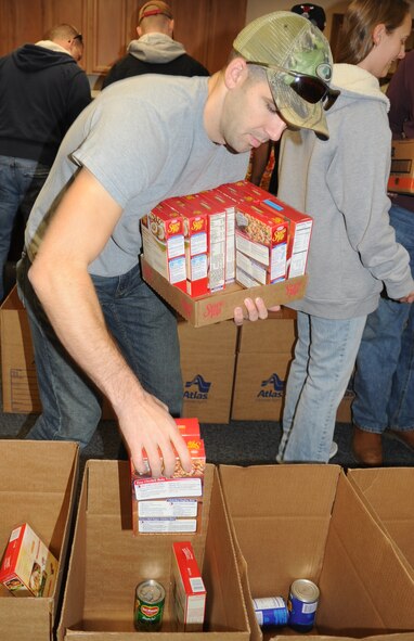 Senior Airman Kenneth Morgan, 4th Equipment Maintenance Squadron munitions inspector, helps pack a Thanksgiving box during the annual Thanksgiving food drive at Seymour Johnson Air Force Base, N.C., Nov. 19, 2011. The boxes will be donated to Airmen identified by their First Sergeants who would benefit most by having the meal provided for them. Morgan hails from Columbus, Ohio. (U.S. Air Force photo by Senior Airman Gino Reyes)