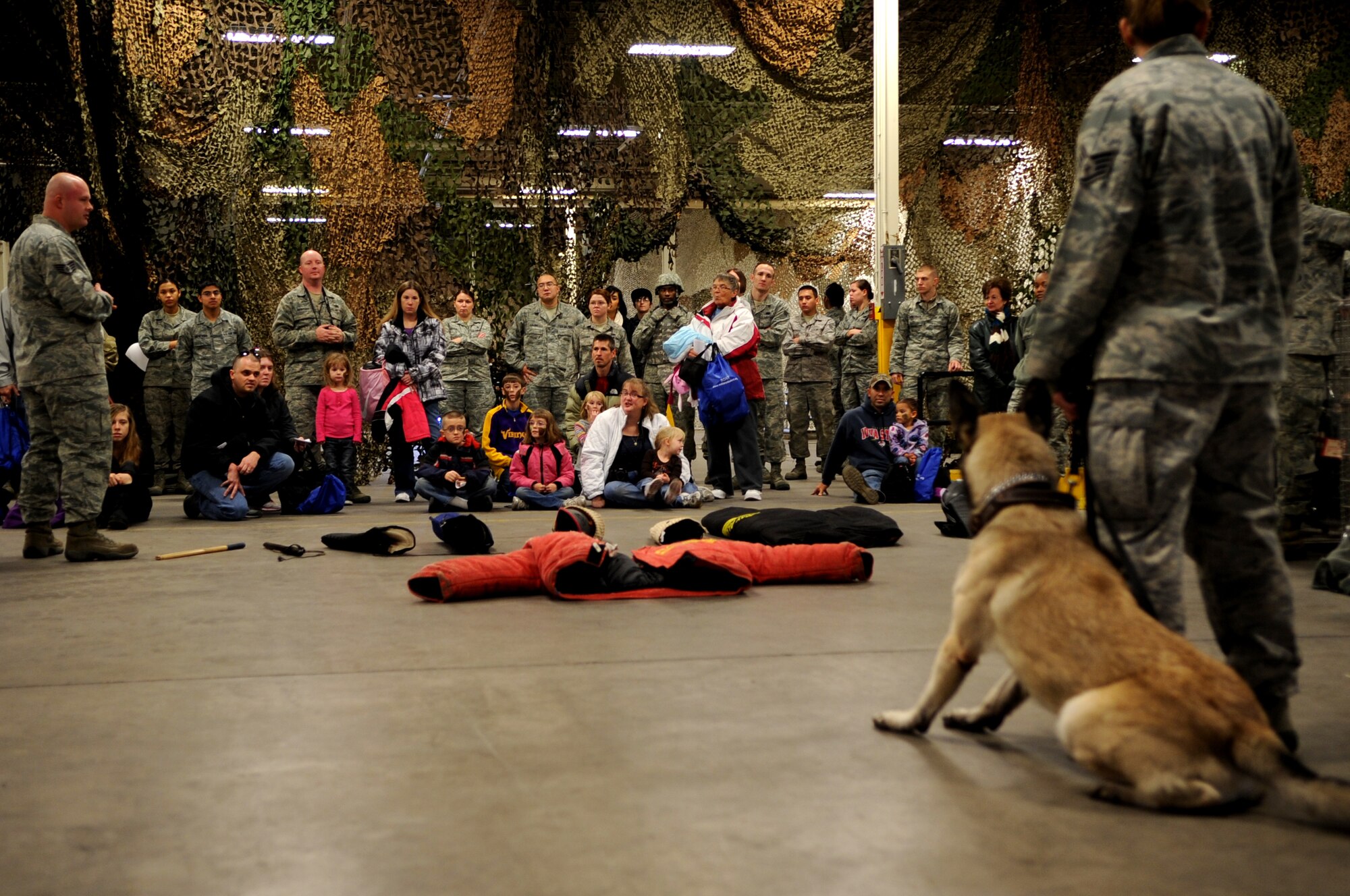Staff Sgt. Jason Laux, 319th Security Force Squadron, gives children a demonstration using the K-9 unit at Grand Forks Air Force Base, N.D., Nov. 19.  The base hosted a deployment line for children of affiliated military families to get a feel of the process when a parent deploys.  (U.S. Air Force photo by Senior Airman Amanda N. Grabiec)