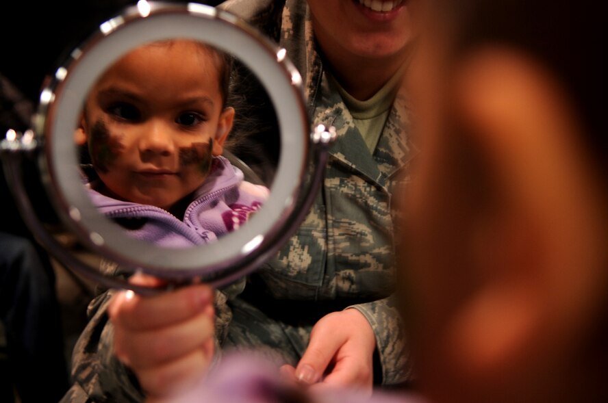 Sadie Tilstra, daughter of Tech. Sgt. Christopher Tilstra, 319th Civil Engineer Squadron, looks at her face paint while at her “deployed location” on Grand Forks Air Force Base, N.D., Nov. 19.  The base hosted a deployment line for children of affiliated military families to get a feel of the process when a parent deploys.  (U.S. Air Force photo by Senior Airman Amanda N. Grabiec)