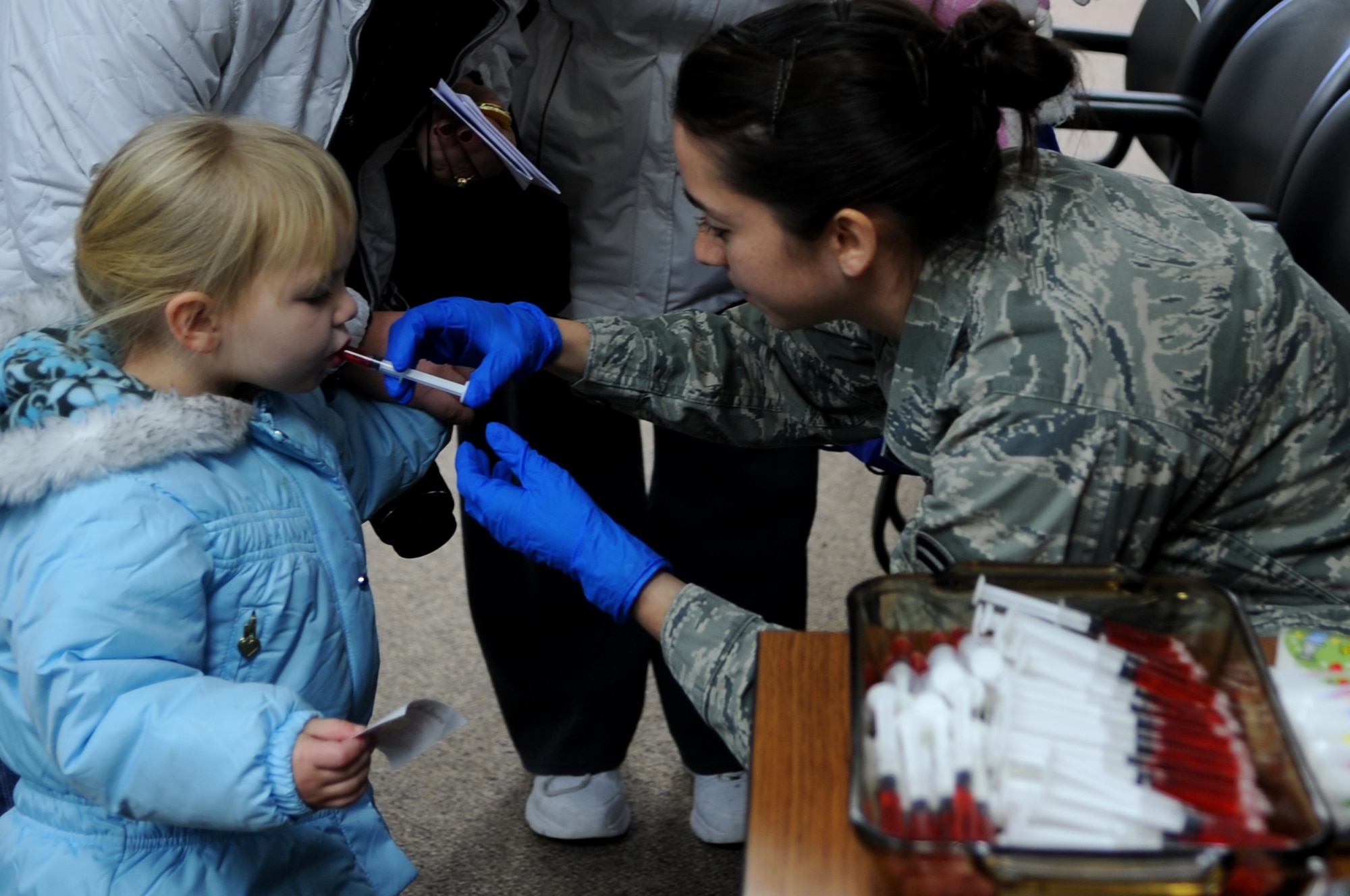Felicity Chegwidden, daughter of Tech. Sgt. Shawn Chegwidden, 319th Force Support Squadron, receives a “simulated” immunization shot while processing the deployment line on Grand Forks Air Force Base, N.D., Nov. 19. The base hosted a deployment line for children of affiliated military families to get a feel of the process when a parent deploys.  (U.S. Air Force photo by Senior Airman Amanda N. Grabiec)