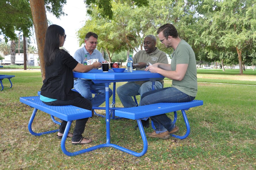 A group of Team March members beta-test a new picnic table at LeMay Park, March Air Reserve Base, Calif., with a game of cards, Nov. 3, 2011.  (counterclockwise from left) Jim Luellen, 452 MOS; Joe Vitelli, 452 MXG; Chaz Hill, 452 MOS; Tylisha Julienne 452 MXG; Mark Brooks, 452 MOS; Kathy Porter, 452 MOS; Tiffany Santamaria, 452 MOS.