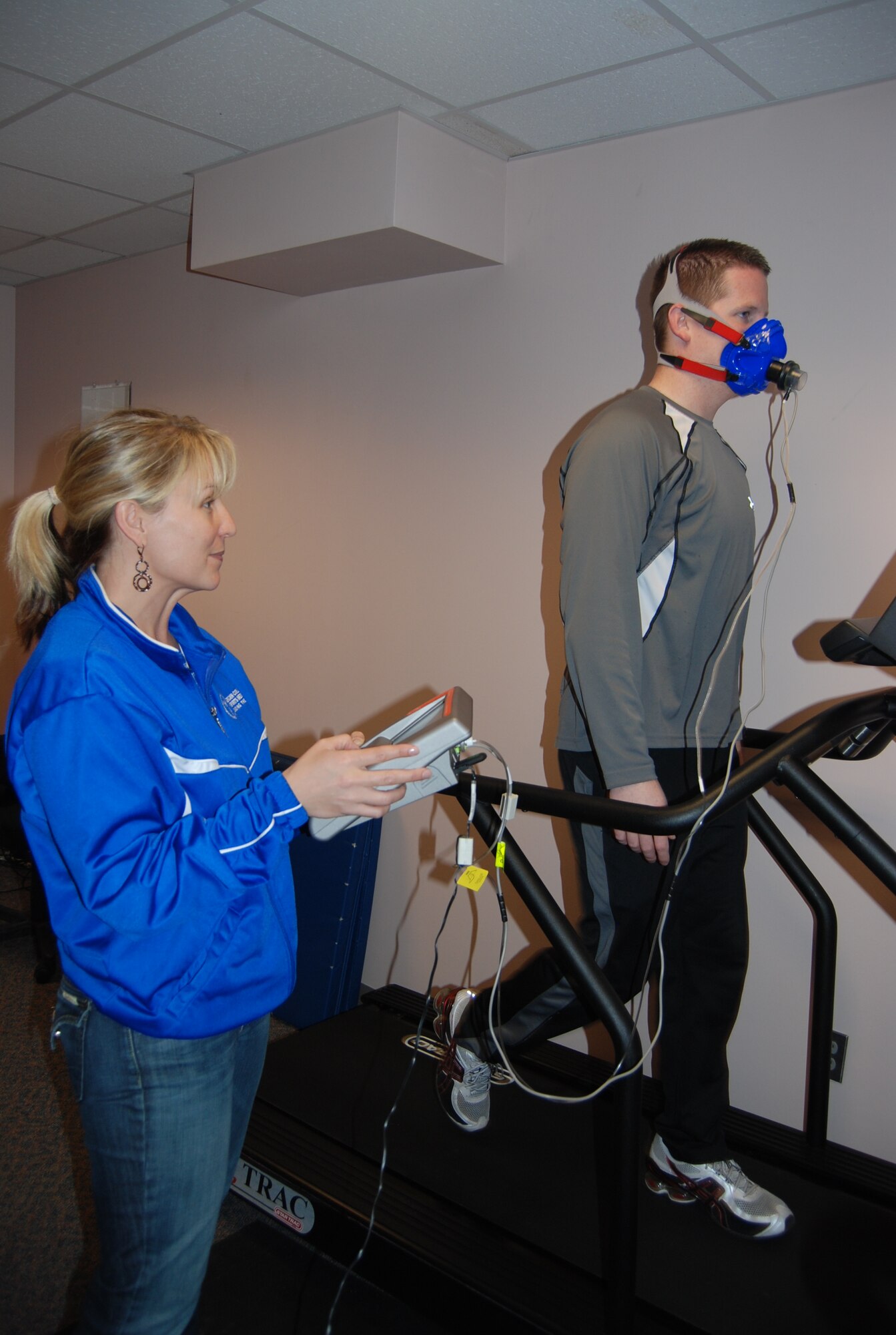 Jennifer Crowley and Charles Hurlbut, Health and Wellness Center exercise physiologists, demonstrate the sub-max VO2 test. The test measures an individual’s resting metabolic rate and configures where anaerobic and baseline training zones should be. The cardio pulmonary exercise testing system is one of three new tools the HAWC has available to Team Pete free of charge. (U.S. Air Force photo/Lea Johnson) 
