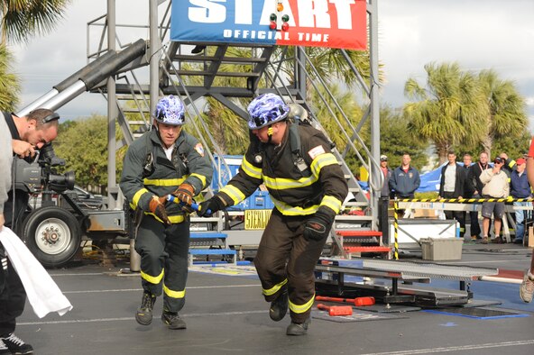 Timothy Vanden Haak of the Whiteman Air Force Base Fire Department passes the baton to Mark Belton during a qualifying run during the World Firefighter Combat Challenge XX Nov. 17, 2011, in Myrtle Beach, S.C.  The Whiteman AFB, Mo., team advanced to the final competition in the men's relay team category and won the silver medal. (U.S. Air Force photo/John Van Winkle)