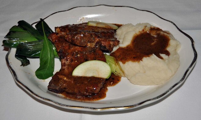 Federico Ramirez, Back Street Cafe cook, presented his finished plate of pan roasted pork with mashed potatoes, to March Top Chef judges, Nov. 15, 2011, at March Air Reserve Base, Calif.  Cooks were given four ingredients, a specific cooking method and 45 minutes to prepare a dish.  (U.S. Air Force photo/Linda Welz)