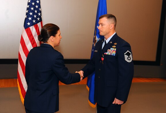 U.S. Air Force Col. Andrea Tullos, 55th Mission Support Group commander, congratulates U.S. Air Force Master Sgt. Dennis W. Carr, 55th Contracting Squadron, after pinning on the Bronze Star at a ceremony in the base theater on Offutt Air Force Base, Neb., Nov. 21. Carr received the Bronze Star for providing critical mission support to more than 130,000 troops while deployed to the Kabul Afghanistan International Airport, and Kandahar Air Field. (U.S. Air Force photo by Josh Plueger/Released).