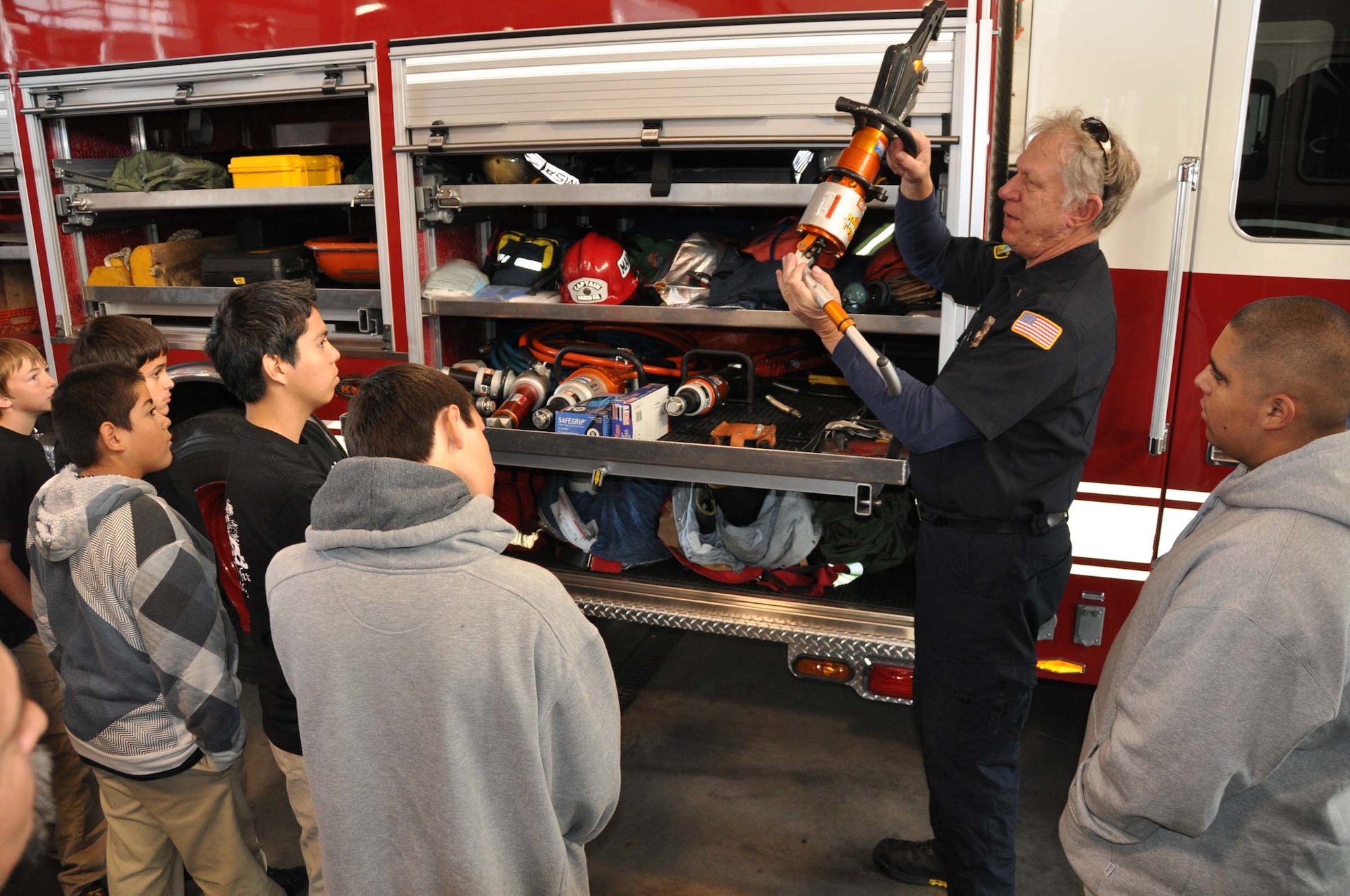 William Albers, an engineer with the March Fire Department, demonstrates the use of fire and rescue equipment to the students of the Norwalk PRIDE program, Nov. 5, 2011, at March Air Reserve Base, Calif. (U.S. Air Force photo/Staff Sgt. Megan Crusher)
