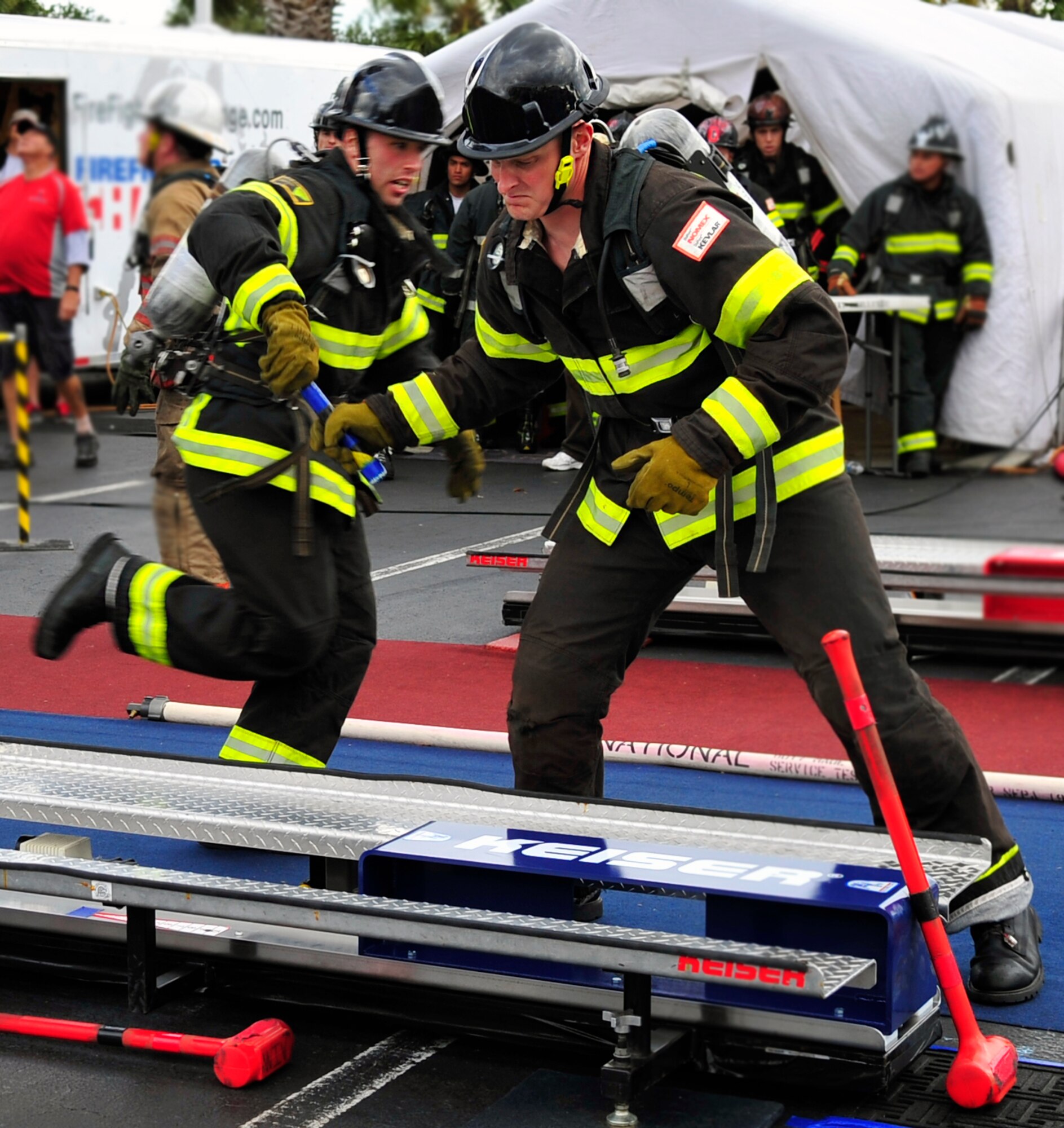 Staff Sgt. Steven Thomas, 20th Civil Engineer Squadron firefighter, passes the baton off to Tech. Sgt. Marcus Hewett, 20th CES firefighter, during the five-man relay at the Scott Firefighter Combat Challenge world competition at Myrtle Beach, S.C., Nov. 15, 2011. The 20th CES firefighters competed against 180 teams from around the world. (U.S. Air Force photo/Airman 1st Class Daniel Phelps/Released)
