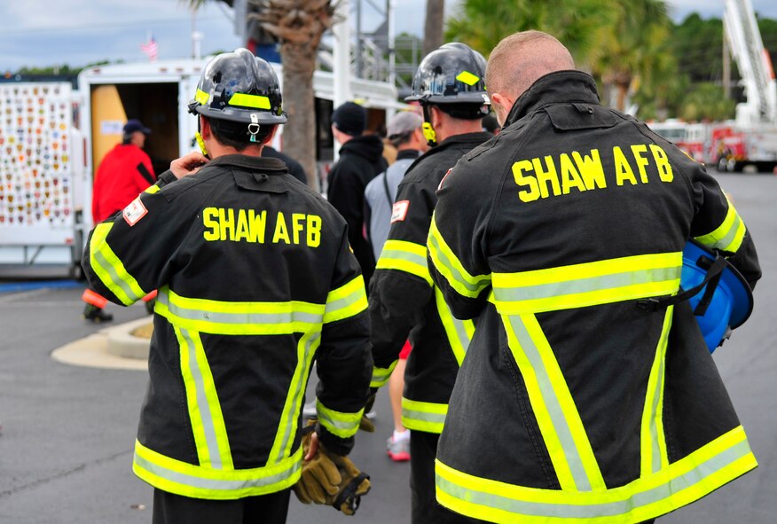 Tech. Sgt. Travis Mills, Airman 1st Class Robert Dentici, and Staff Sgt. Chastin Warner, 20th Civil Engineer Squadron firefighters, walk up to the check-in tent to get ready for their relay at the Scott Firefighter Combat Challenge world competition at Myrtle Beach, S.C. Nov. 17, 2011. The 20th CES firefighters  competed against 180 teams from around the world. (U.S. Air Force photo/ Airman 1st Class Daniel Phelps/Released)