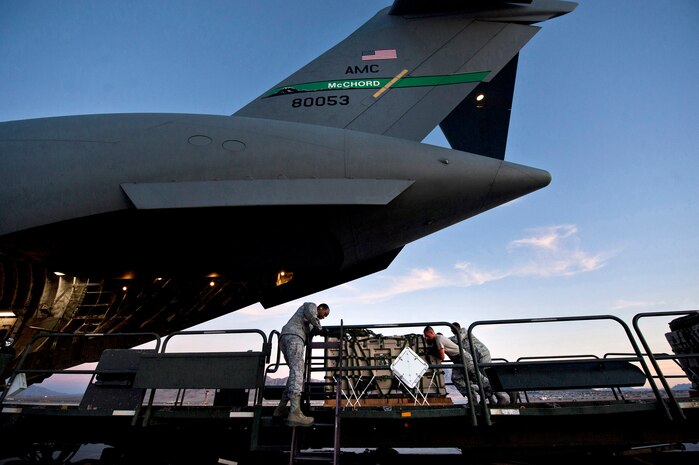 U.S. Air Force Airmen push cargo off of a 60K Tunner Cargo Loader into a C-17 Globemaster during Mobility Air Forces Exercise on Nov. 15, 2011, at Nellis Air Force Base, Nev. The C-17 r and C-130 Hercules cargo aircraft will assemble in aerial formations over the Nevada Test and Training Range to conduct air and ground operations as part of the bi-annual, U.S. Air Force Weapons School Mobility Air Forces Exercise. (U.S. Air Force photo by Airman 1st Class George Goslin/Released)
