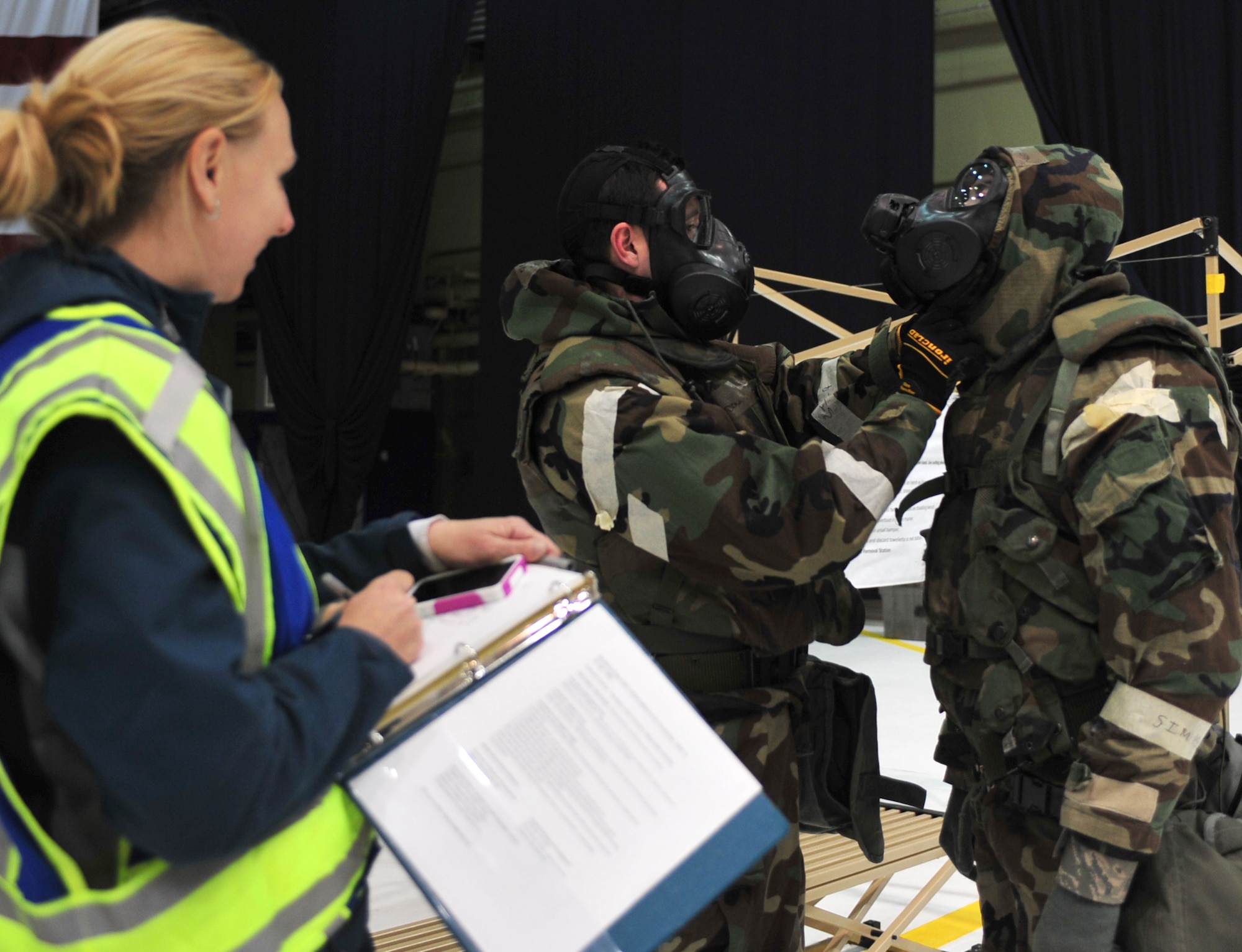 Emergency Manager, Elizabeth Ross, inspects Airmen who use the buddy system to don Mission Oriented Protective Posture gear during Exercise Polar Force 11-10 at Joint Base Elmendorf-Richardson, Alaska, Nov. 17, 2011. The exercise is made up of a variety of scenarios which test the arctic warriors' ability to handle real world situations. Ross is assigned to the 773d Civil Engineer Squadron. (U.S. Air Force photo/Staff Sgt. Sheila deVera)