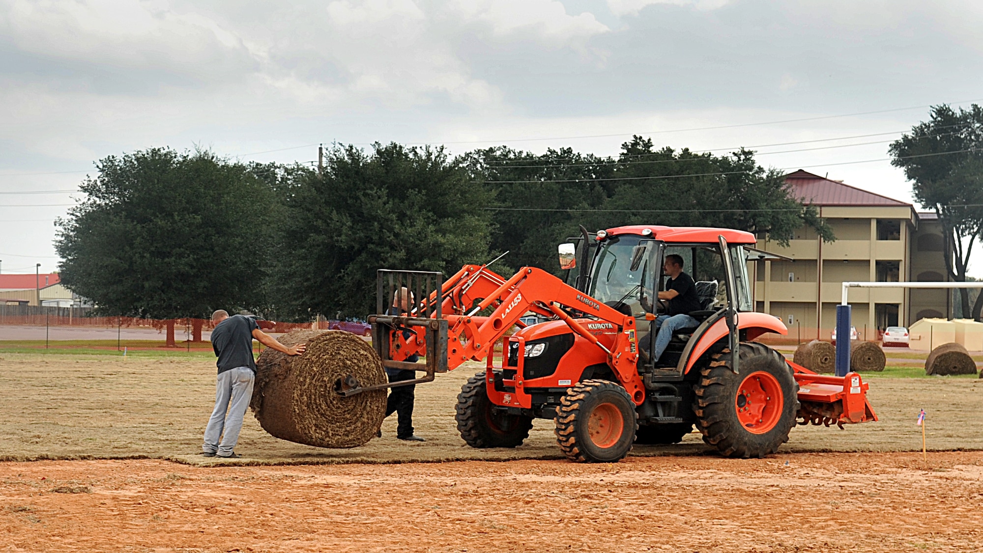 Contractors Brett Dunn and Trey Hicks prepare to lay bermuda grass on the field in front of the fitness center on Barksdale Air Force Base, La., Nov. 21. Although the construction will be completed in December, the field will not be open to the public until July 2012 so the grass has an ample amount of time to grow and root itself in the ground. (U.S. Air Force photo/Senior Airman Kristin High)(RELEASED)