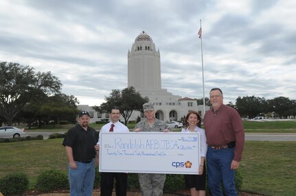 Col. Scott Peel (center), 902nd Mission Support Group commander, recieves a check Nov. 22 from Yvonne Haecker, City Public Service representative ,for Joint Base San Antonio-Randolph's contribution toward conservering energy throuhout the summer months. Also pictured are JBSA-Randolph energy managers (from left), Shawn Church, Ruben Ramos and Bruce Dschuden. (U.S. Air Force photo/Joel Martinez)