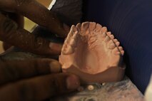 MINOT AIR FORCE BASE, N.D. -- Master Sgt. Troy Myles, 5th Medical Operations Squadron dental lab NCO in charge, grinds down a lower arch on a cast trimmer machine, here Nov. 16. The dental lab customizes a variety of products such as crowns, bridges and dentures to assist in the provision of oral health care. (U.S. Air Force Photo/Airman 1st Class Desiree Esposito)