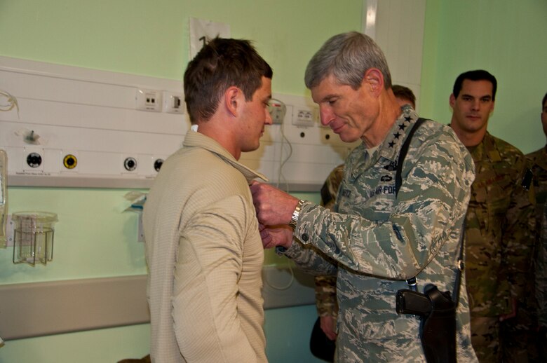 KANDAHAR AIRFIELD, Afghanistan -- Air Force Chief of Staff Gen. Norton Schwartz presents the Purple Heart to Senior Airman Taras Ivaniuk at Kandahar Airfield, Nov. 16, 2011. Ivaniuk is a pararescueman who recently sustained wounds during a personnel recovery mission. (U.S. Air Force photo/Senior Airman David Carbajal)