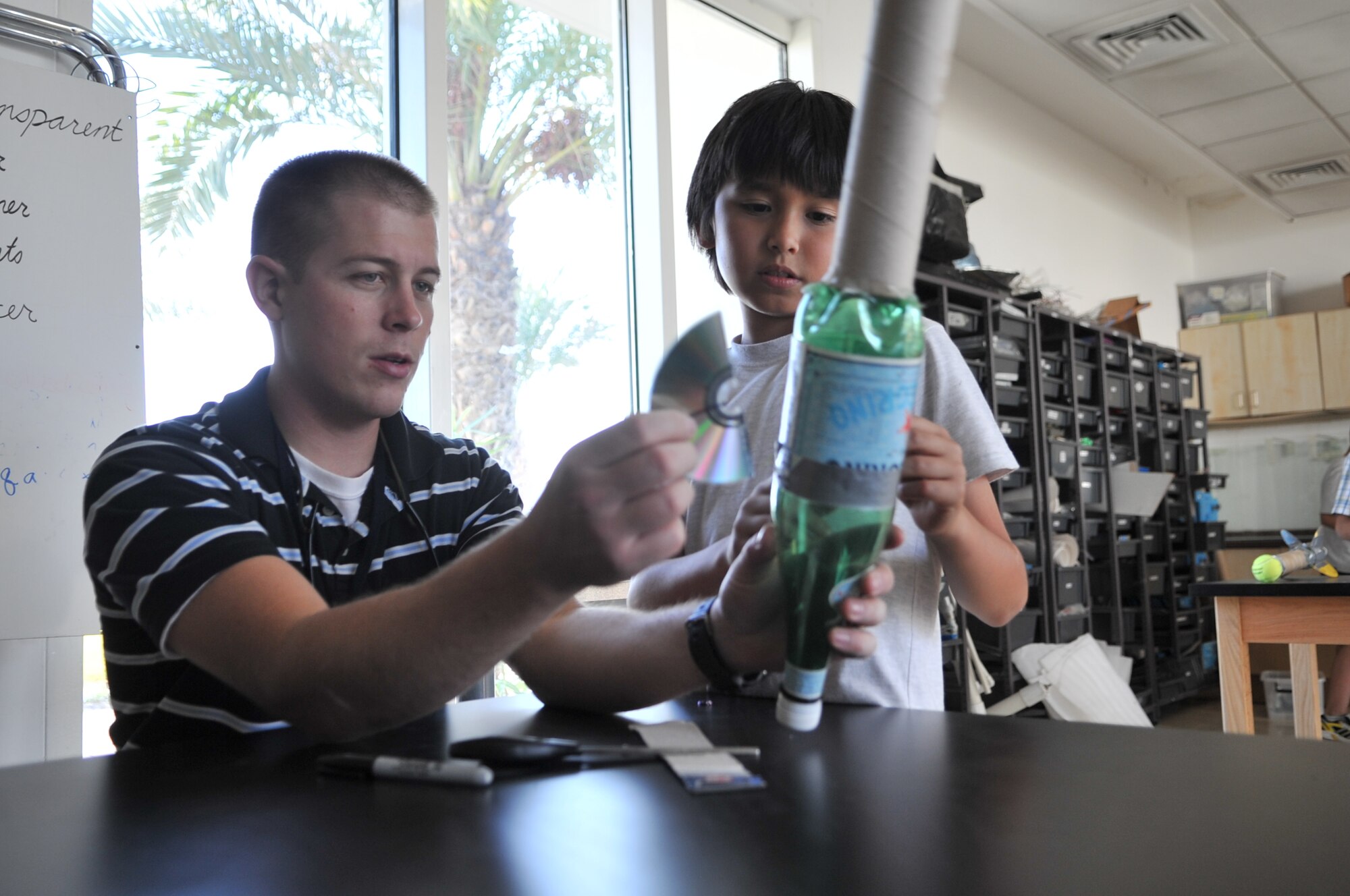 Tech. Sgt. Kyle Tecmire, U.S. Air Forces Central Command cyber transport technician, helps a student from a local school assemble a water-propelled rocket Nov. 20 at an undisclosed location in Southwest Asia. Each of the 20 students launched hand-built rockets crafted out of water bottles, cardboard and duct tape as part of the Science and Technology Advancement and Relationships (STARS) program. Tecmire, a native of Medford, Ore., is deployed from Kingsley Field, Ore. (U.S. Air Force photo/Senior Airman Paul Labbe)