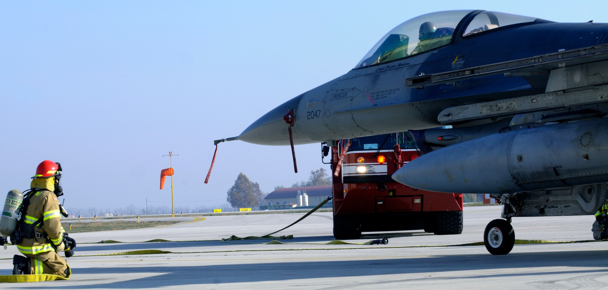 An Aviano firefighter prepares to extract an Airman from an F-16 Fighting Falcon as part of an aircraft egress procedures and familiarization exercise Nov. 19 at Aviano Air Base, Italy. The purpose of the exercise was to show the Slovenian firefighters the different procedures and tools used  to remove a pilot from a smoking cockpit.  (U.S. Air Force Photo/Airman 1st Class Briana Jones)
