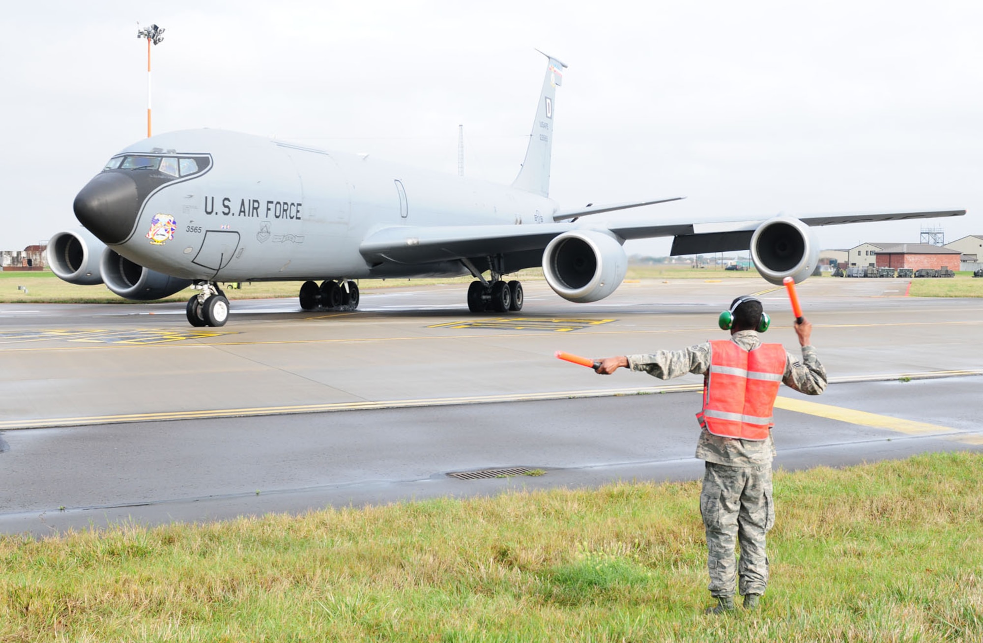 RAF MILDENHALL, England -- Senior Airman Terrence McIlwain, 100th Aircraft Maintenance Squadron crew chief, marshals a KC-135 Stratanker out of its spot as the aircrew prepare to launch Nov. 9, 2011. Made up of three career fields – crew chiefs, hydraulics and propulsion specialists – APG formerly meant “airplane general,” and though the name is no longer officially used, it’s still kept for its historical roots.The 100th AMXS APG crew chiefs perform all necessary safety inspections, both on and off the jet, starting many hours before takeoff. Once all checks are complete and everything is found to be as it should, they then marshal the jet out so it can take off, and again once it lands. (U.S. Air Force photo/Karen Abeyasekere)