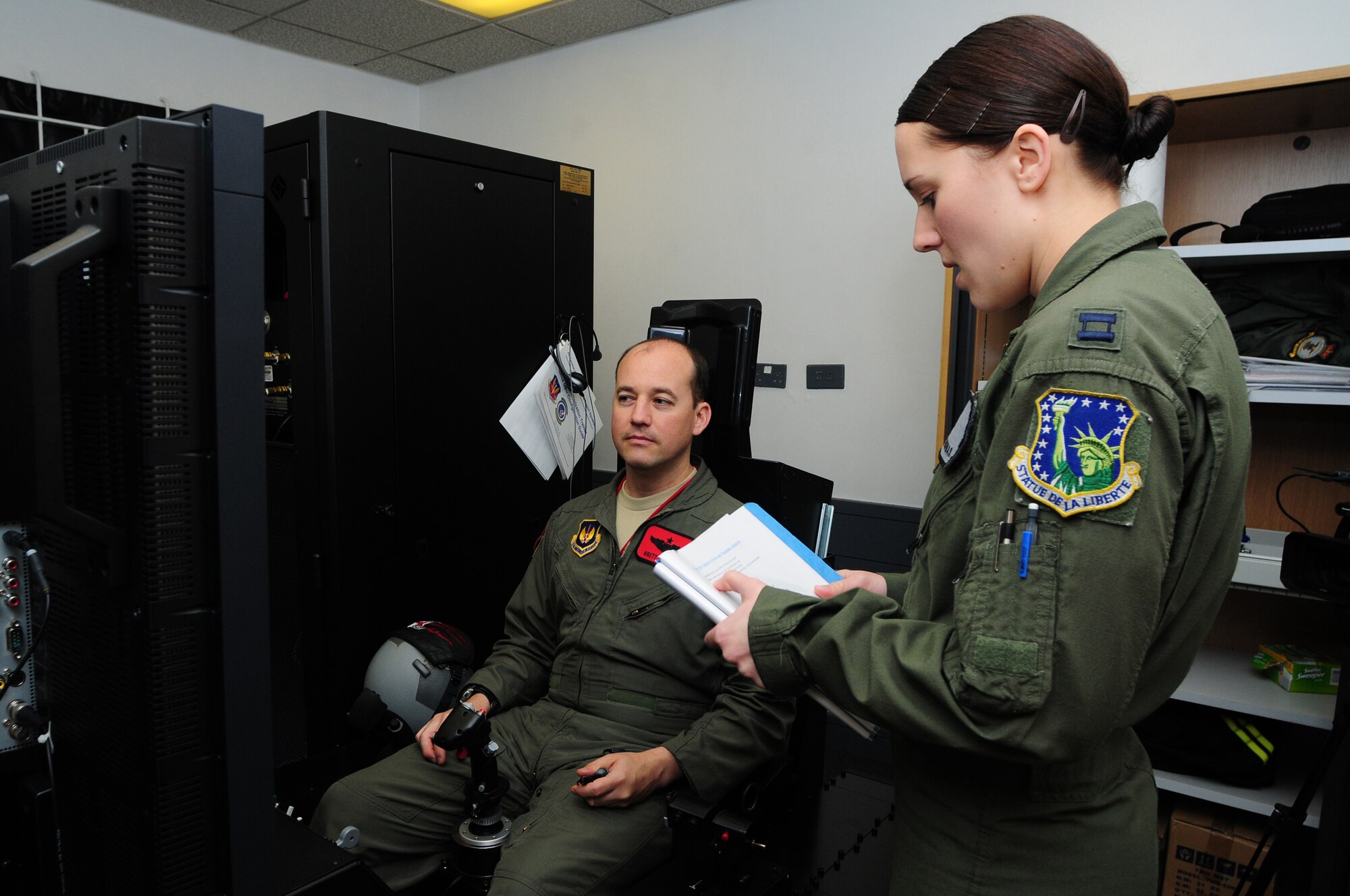 ROYAL AIR FORCE LAKENHEATH, England - Capt. Ashley Thomas, 48th Aerospace Medicine Squadron aerospace and operational physiology officer in charge, briefs Lt. Col. Jonathan Taylor, 494th Fighter Squadron director of operations, before training in the Reduced Oxygen Breathing Device/Hypoxia Familiarization Trainer, Nov. 18, 2011. The trainer provides aircrew members the ability to still experience a simulated altitude change without the added pressure changes and risks when using an altitude chamber. (U.S. Air Force photo by Senior Airman Lausanne Morgan)