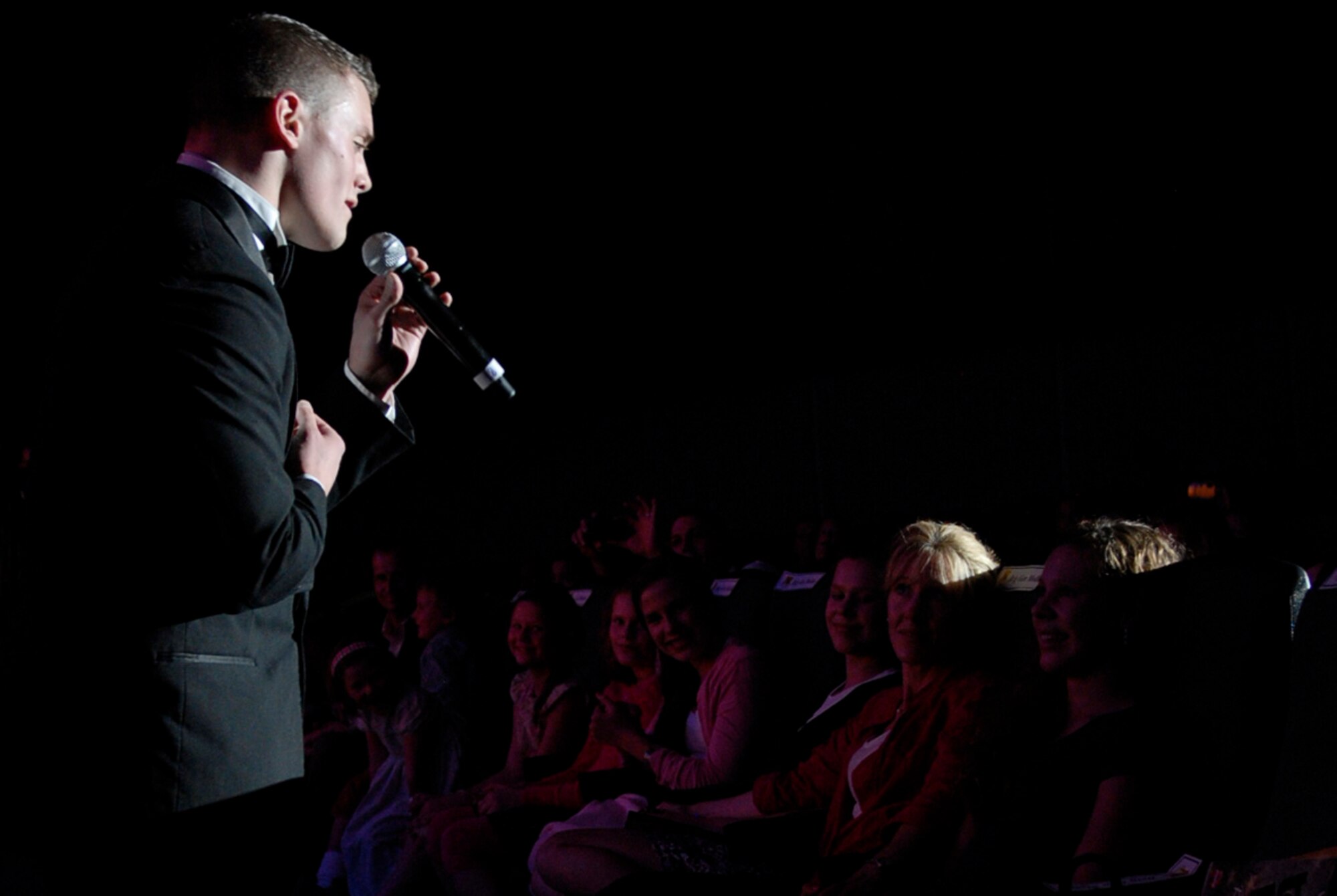 U.S. Air Force 1st Lt. Robert Doyle, Tops in Blue 2011 officer in charge and vocalist, serenades a daughter of U.S. Air Force Brig. Gen. Matthew Molloy, 18th Wing commander, during a performance at the Keystone Theater on Kadena Air Base, Japan, Nov. 17, 2011. For nearly 60 years, Tops in Blue has maintained their motto of "family entertaining family." Doyle is a 4th Space Launch Squadron acquisitions program manager from Vandenberg Air Force Base, Calif., and an Avon Lake, Ohio, native. (U.S. Air Force photo by Airman 1st Class Tara A. Williamson/Released)