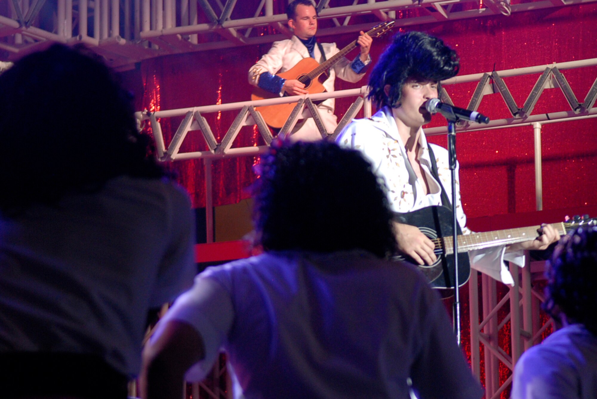 U.S. Air Force Senior Airman Cordero Nichols, Tops in Blue 2011 vocalist, sings as Elvis Presley to his adoring "fans" made up of female Tops in Blue 2011 members at the Keystone Theater on Kadena Air Base, Japan, Nov. 17, 2011. The 2011 world tour is entitled Rhythm Nation, as it takes the audience through an evolution of music throughout the decades. Nichols is a 301st Intelligence Squadron communications signals intelligence production journeyman from Misawa Air Base, Japan, and a Pleasant Hills, Mo., native. (U.S. Air Force photo by Airman 1st Class Tara A. Williamson/Released)