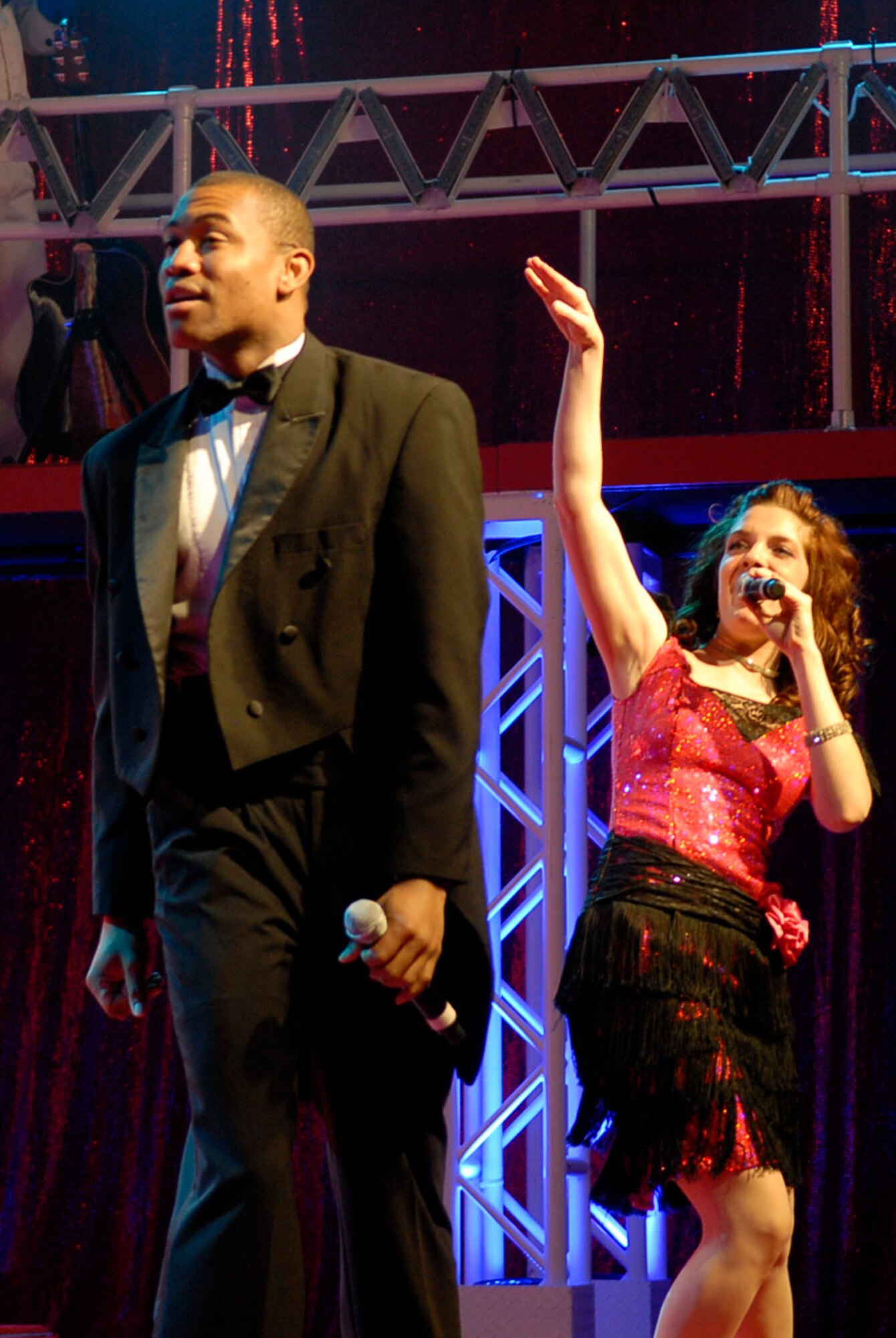 U.S. Air Force Airmen 1st Class Jarrod Burton and Aimee Grills, Tops in Blue 2011 vocalists, perform a duet during the Rhythm Nation tour at the Keystone Theater on Kadena Air Base, Japan, Nov. 17, 2011. The group's three-day stop at Kadena is just one of many during the 2011 world tour. Burton is a 90th Civil Engineer Squadron water fuels maintenance journeyman from F.E. Warren Air Force Base, Wyo., and Houston, Tex., native, and Grills is a 354th Civil Engineer Squadron engineering apprentice from Eielson Air Force Base, Alaska, and a Chesterfield, Ind., native. (U.S. Air Force photo by Airman 1st Class Tara A. Williamson/Released)