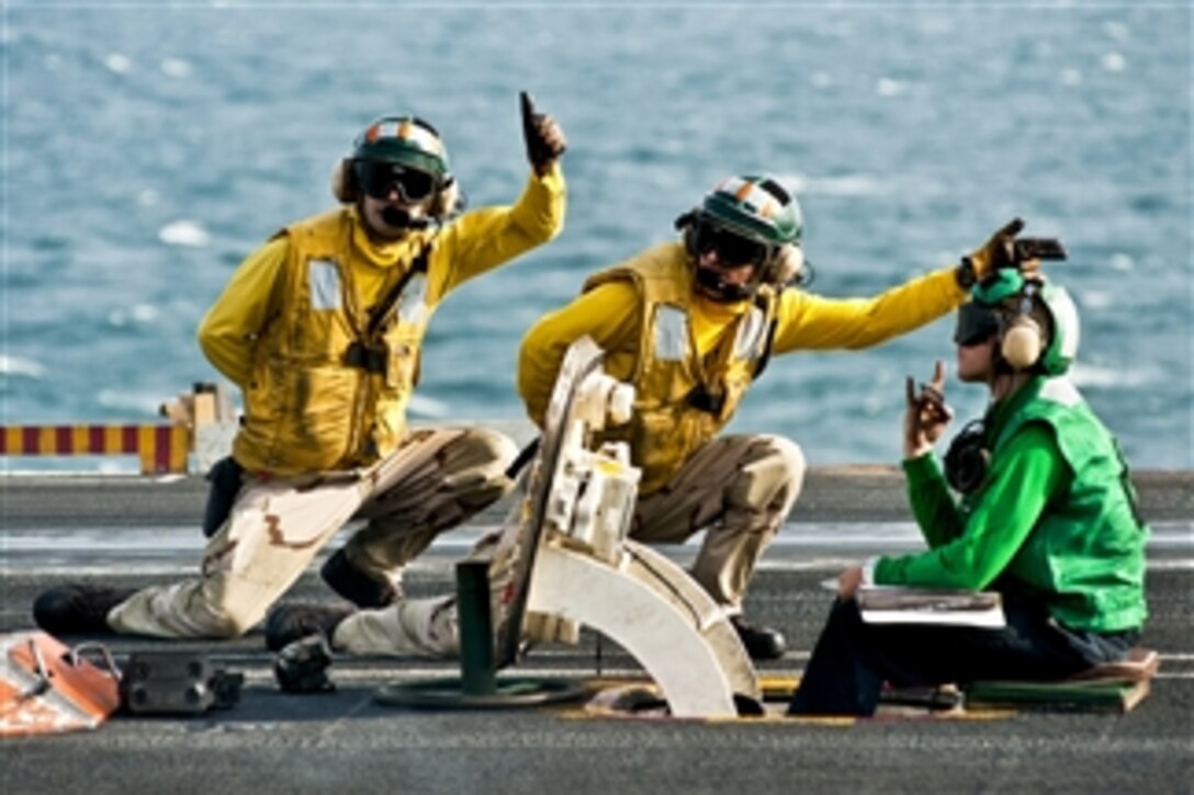 U.S. Navy sailors signal the launch of an F/A-18F Super Hornet assigned to Strike Fighter Squadron 41 aboard the aircraft carrier USS John C. Stennis in the Arabian Gulf on Nov. 20, 2011.  The Stennis is conducting maritime security operations and support missions as part of Operation Enduring Freedom and New Dawn.  