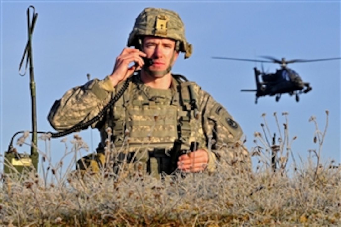 U.S. Army Cpt. Troy Peterson directs an AH-64 Apache attack helicopter strike on a target at the Close Combat Attack lane during the U.S. Army Europe Best Junior Officer Competition at the U.S. Army Garrison Grafenwoehr in Germany on Nov. 15, 2011.  Peterson is assigned to the 2nd Cavalry Regiment.  