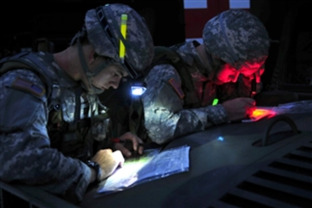 U.S. Army Cpt. Nick Franck (left) and 2nd Lt. Charles Smith (right) plot their points on maps for the day-to-night land navigation course during the U.S. Army Europe Best Junior Officer Competition at the U.S. Army Garrison Grafenwoehr in Germany on Nov. 16, 2011.  Franck is assigned to the 12th Combat Aviation Brigade and Smith is assigned to the 18th Engineer Brigade.  