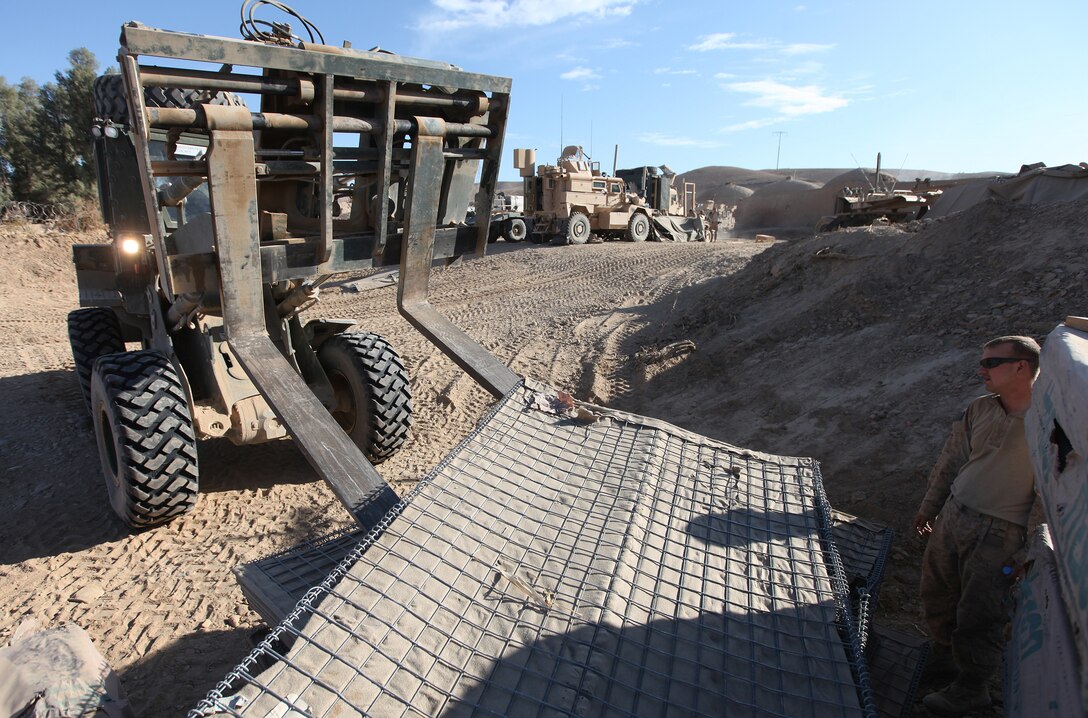 Lance Cpl. Scott Steffens (right), of Traverse City, Mich., guides a fork truck operated by Lance Cpl. Ryan Anderson, of Applegate, Ore., into place at Patrol Base New Jersey, Afghanistan, Nov. 23. Both Marines are heavy equipment operators with Combat Logistics Company 6, 2nd Marine Logistics Group (Forward). The CLC, which is comprised of two engineer platoons and one motor transportation platoon, is an element of Combat Logistics Battalion 6 and was formed to provide direct support to 1st Battalion, 6th Marine Regiment, during Operation Eastern Storm. Engineers were tasked with building several of the patrol bases along Route 611. (U.S. Marine Corps photo by Sgt. Justin J. Shemanski)