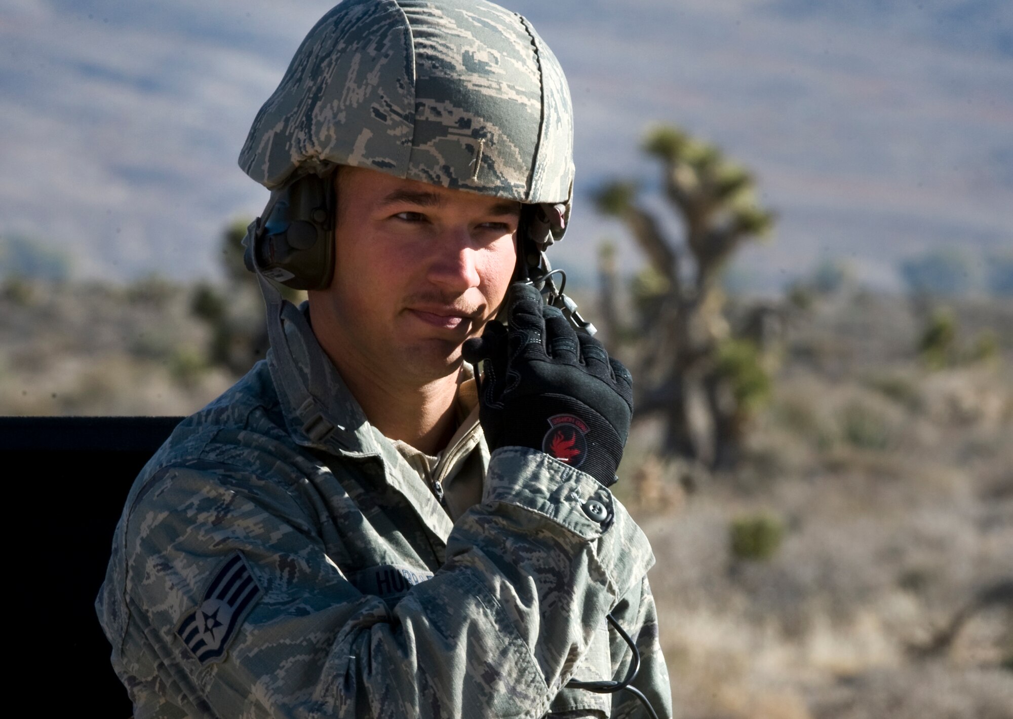 U.S. Air Force Staff Sgt. Sean McCarty, 820th RED HORSE Squadron airborne flight, communicates with a CH-47 Chinook, Army National Guard, Stockton, CA, via radio during a peacetime operation Nov. 9, 2011, at Alamo, Nev.The sling load training and air assault certification of 820th RHS airborne flight Airmen proved crucial in the success of the quick response operation. (U.S. Air Force photo by Tech Sgt. Bob Sommer/Released)
