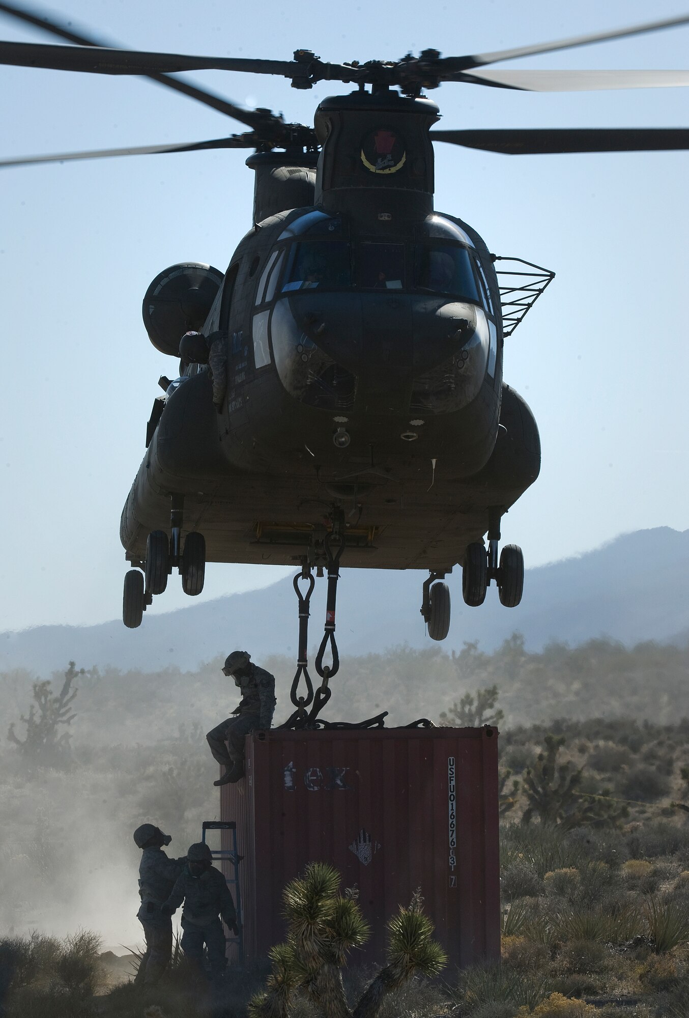 U.S. Air Force Airmen, 820th RED HORSE Squadron airborne flight, completes a connex box sling load to a CH-47 Chinook, Army National Guard, Stockton, CA, during a peacetime operation Nov. 9, 2011, at Alamo, Nev.The sling load training and air assault certification of 820th RHS airborne flight Airmen proved crucial in the success of the quick response operation. (U.S. Air Force photo by Tech Sgt. Bob Sommer/Released)