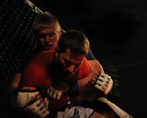 Staff Sgt. Alan Wood, Air Force reservist, in the red shirt, struggles to move out of the corner during Galaxy Fight Night at Champions Indoor Soccer Arena in Yuba City, Calif. Nov. 19, 2011. Fighters have an advantage when they have their opponent cornered. (U.S. Air Force photo by Airman 1st Class Samuel W. Sanders/Released)