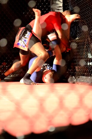 Staff Sgt. Francisco Garrigas, 9th Maintenance Group, takes down his opponent during a mixed martial arts fight, Yuba City, Calif. Nov. 19, 2011. Garrigas spent an hour and a half warming up to take his opponent down in a matter of minutes during the first round. (U.S. Air Force photo by Airman 1st Class Ayla Ramirez/Released)