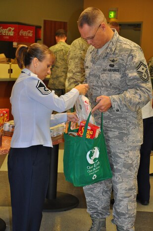 Master Sgt. Rebecca Hancock, 9th Medical Support Squadron, helps another Beale first Sergeant put the finishing touches on a turkey basket at the Community Activity Center on Beale Air Force Base Nov. 21, 2011. The baskets were made by the First Sergeants Council for Operation Warm Heart. (U.S. Air Force photo by Staff Sgt. Robert M. Trujillo/Released)  