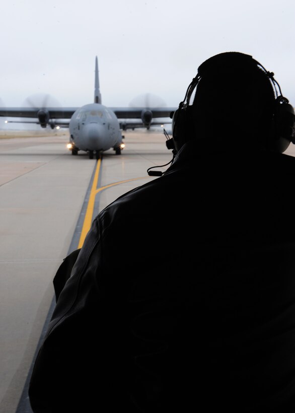 An airman watches C-130s line up for takeoff during an airlift group exercise Nov. 22, 2011 at Dyess Air Force Base, Texas. Conducting exercises ensures airmen are capable of bringing support to foreign land. (U.S. Air Force photo by Airman 1st Class Jonathan Stefanko/ Released) 
