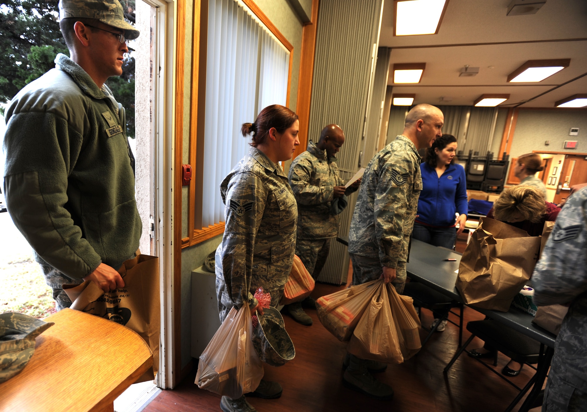 Team McConnell Airmen carry in food donations for the Thanksgiving Basket giveaway Nov. 22, 2011, McConnell Air Force Base, Kan. One hundred and thirty-eight traditional Thanksgiving Day meal “baskets” were assembled, surpassing this year’s goal of 120. (U.S. Air Force photo/ Airman 1st Class Laura L. Valentine)