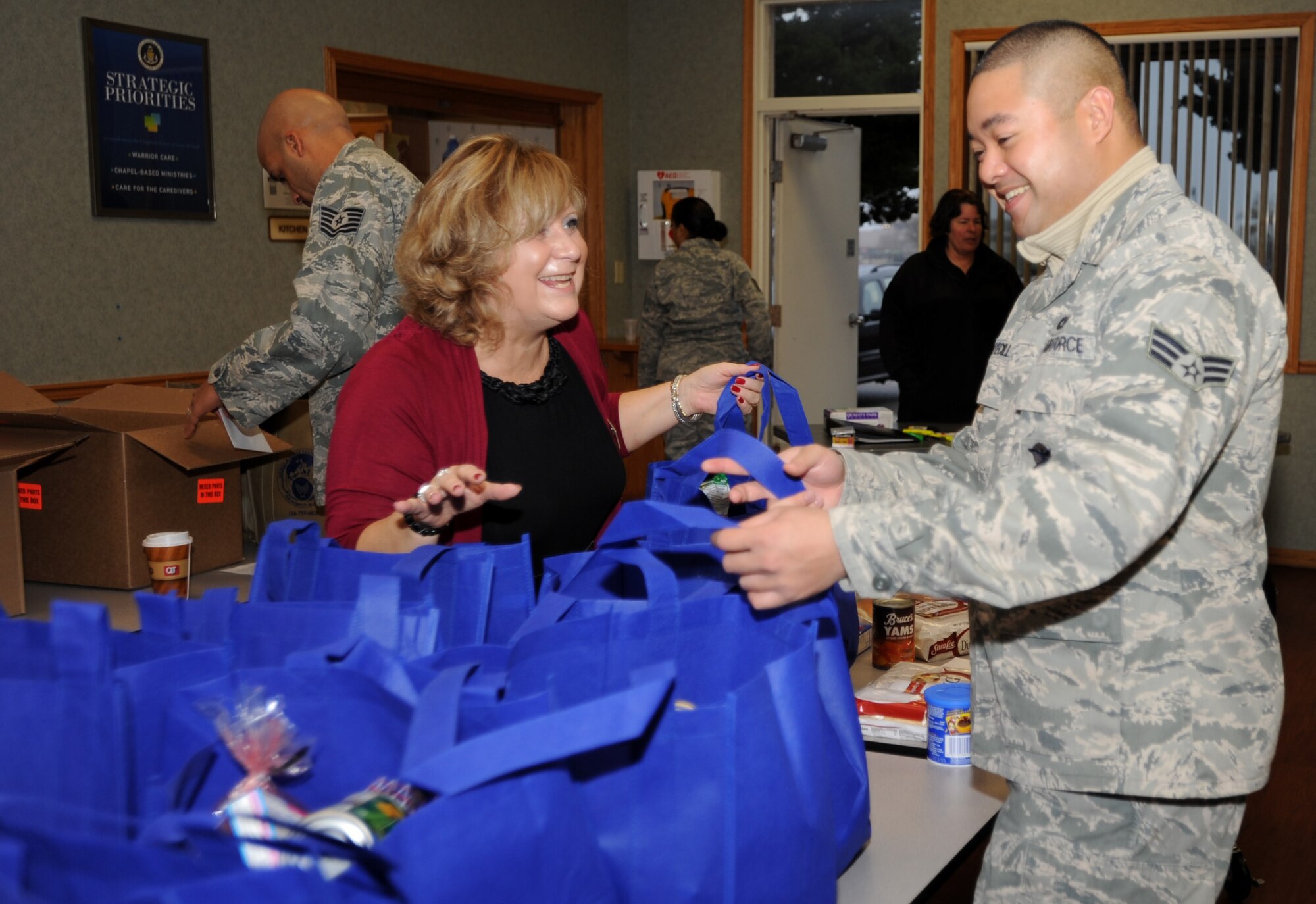 Maryann Barry, Airman and Family Readiness Center community readiness consultant, and Riz Edgar Fuentecilla, 22nd Security Forces Squadron NCO in charge of police services, sort food for Thanksgiving “baskets” at the base chapel annex, Nov. 22, 2011, McConnell Air Force Base, Kan. One hundred and thirty-eight baskets were assembled and delivered to McConnell Airmen. (U.S. Air Force photo/ Airman 1st Class Laura L. Valentine)