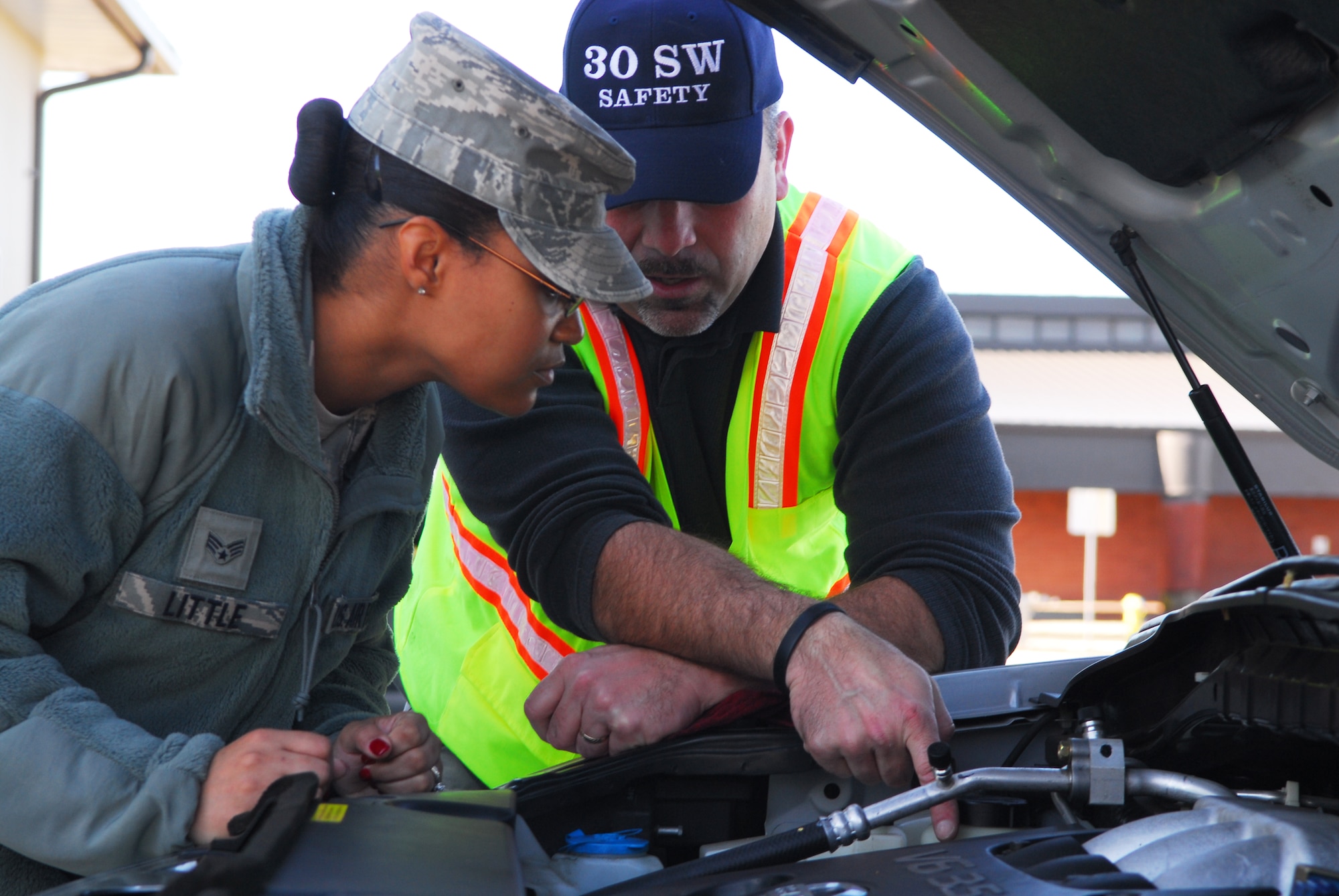 VANDENBERG AIR FORCE BASE, Calif. – During a free vehicle safety check inspection provided by the 30th Space Wing Safety Office, Senior Airman Chanel Little, a 30th Medical Support Squadron pharmacy technician, is shown how to check the fluid levels in her automobile by Michael Trudeau, a 30th SW safety specialist, at the Army and Air Force Exchange Service Car Care Center’s parking lot here Wednesday, Nov. 23, 2011. (U.S. Air Force photo/Senior Airman Steve Bauer)    