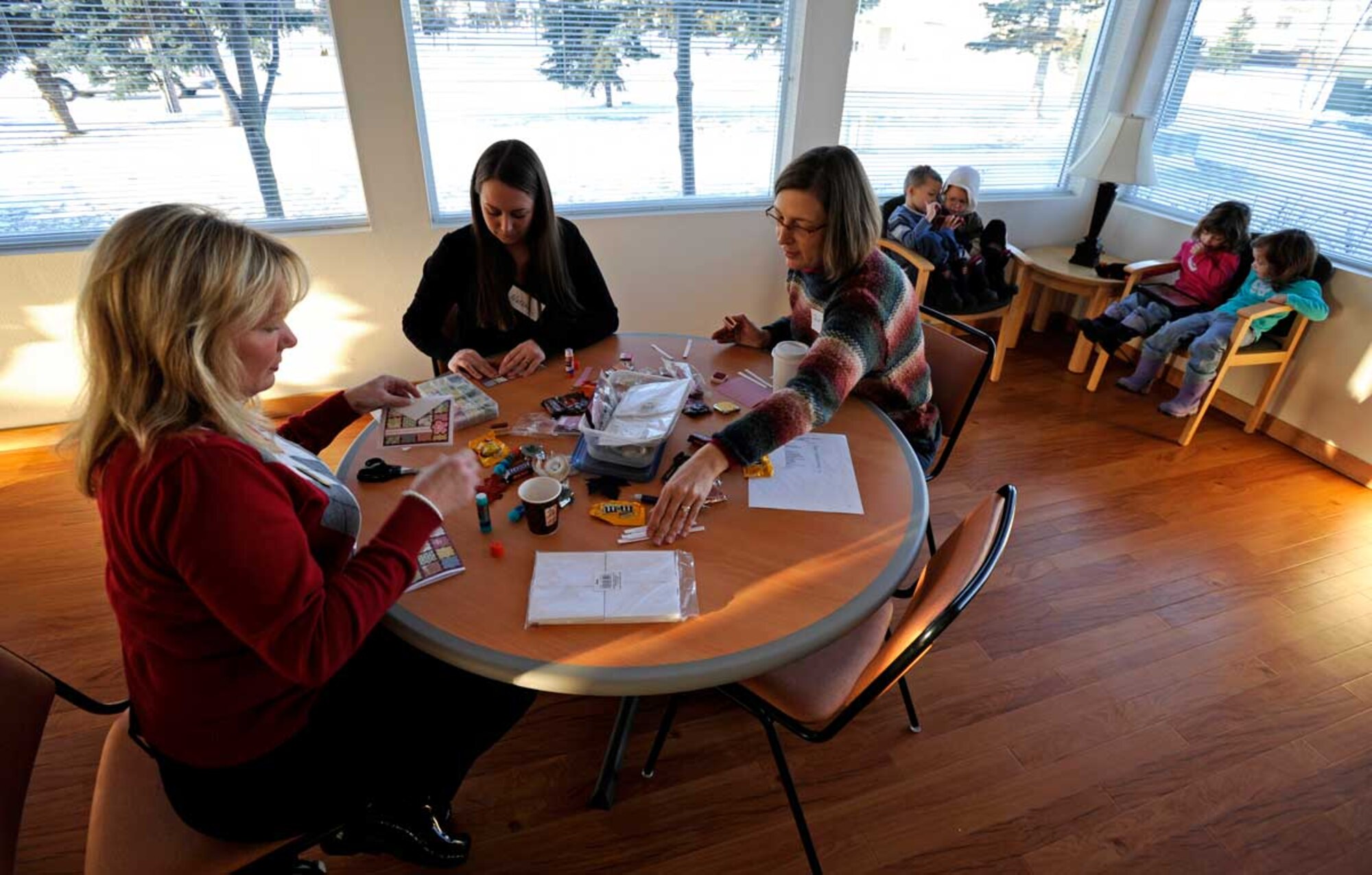 Elizabeth Hula, left, Natalie Kecker, center, and Julie Matta prepare greeting cards during Operation Write Home at the Dallas Community Center on Joint Base Elmendorf-Richardson, Nov. 17.  Operation Write Home, a program started in 2007, provides hand-made greeting cards to deployed service members so they can write home to family and friends. Members of the Elmendorf Officers’ Spouses Organization and Elmendorf Enlisted Spouses’ Club made the cards. (U.S. Air Force photo/Staff Sgt. Brian Ferguson)