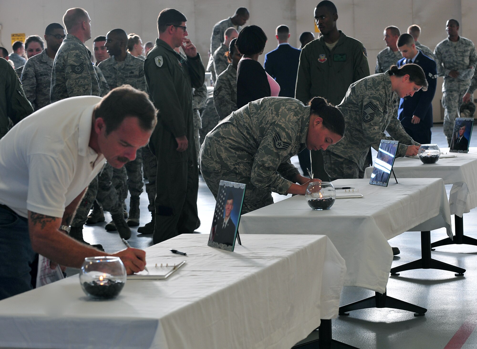 Members of Team Moody sign guestbooks during a memorial service at Moody Air Force Base, Ga., Nov. 22, 2011. Family, friends and coworkers showed their respect for three young Airmen who recently lost their lives after a single-vehicle automobile accident. (U.S. Air Force photo by Staff Sgt. Stephanie Mancha/Released) 

