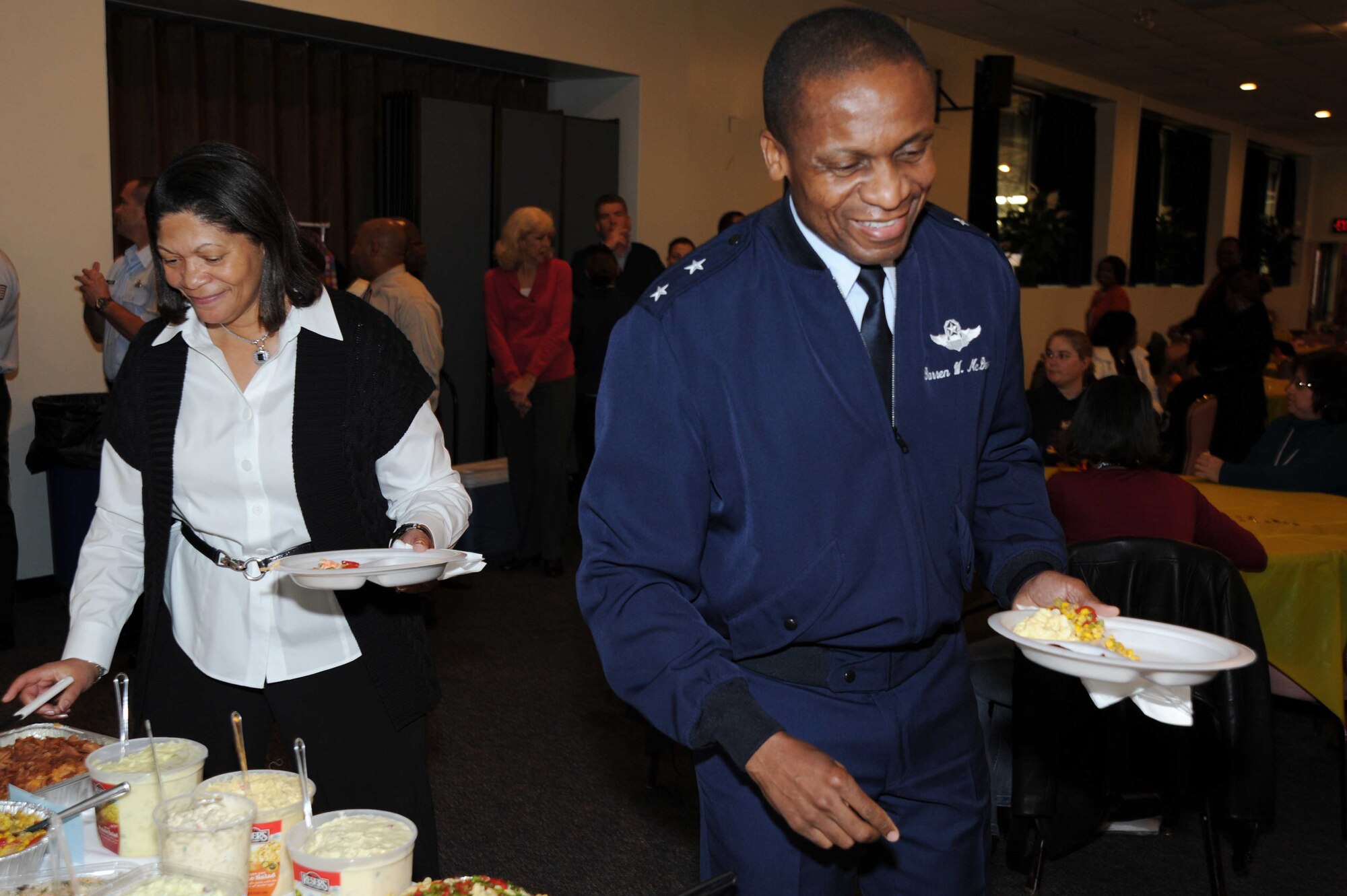 Maj. Gen. Darren McDew and his wife Evelyn lead Air Force District of Washington teammates down the buffet line during a Thanksgiving feast at the Andrews Community Activity Center Nov. 17. The general and his wife took the time to say "thank you" to all those gathered at the holiday event. 