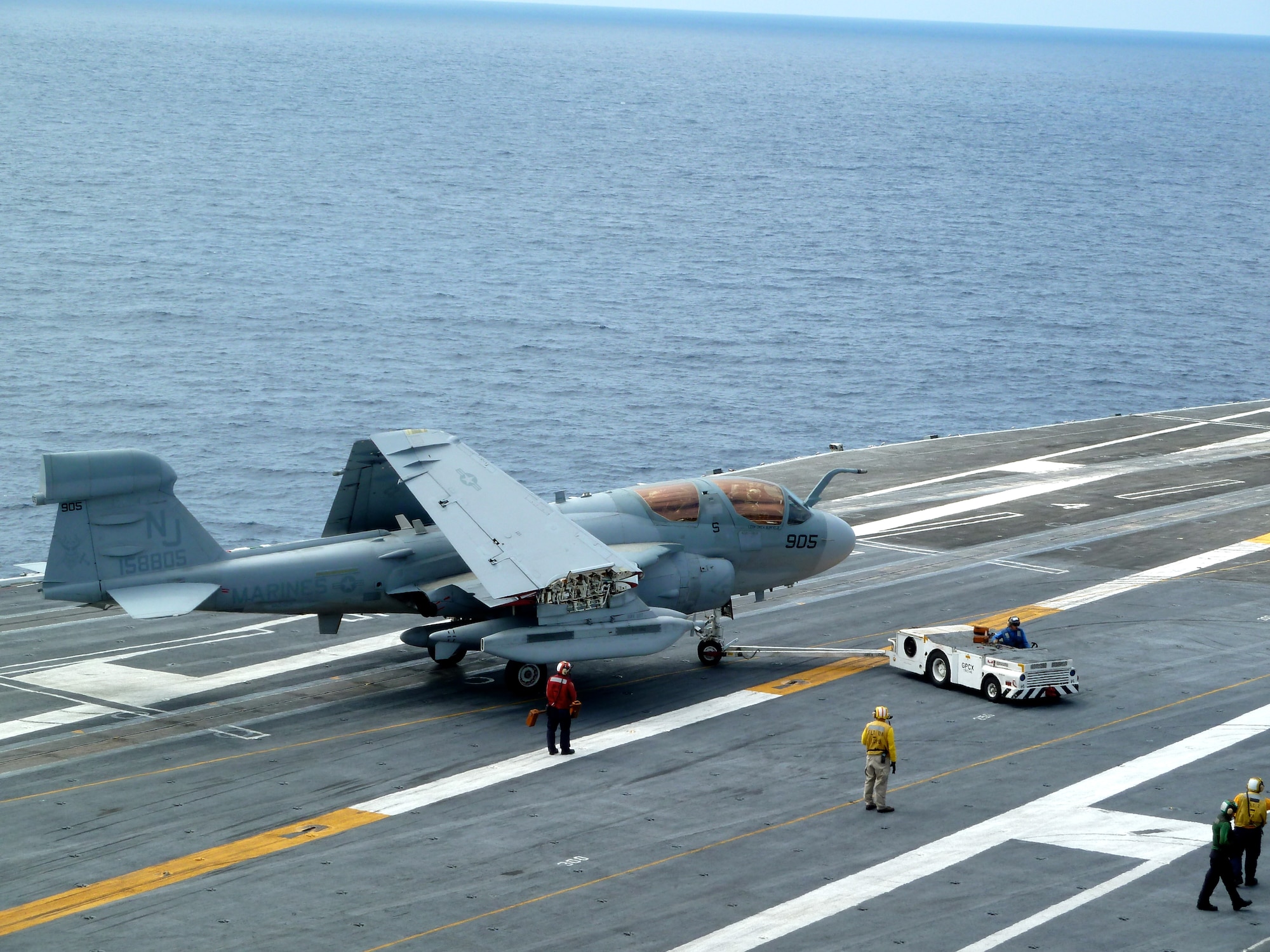 A tow tractor maneuvers an EA-6B Prowler across the deck of the Nimitz-class aircraft carrier USS Dwight D. Eisenhower (CVN 69) Sept. 13, 2011, while underway in the Atlantic Ocean. Specific aircraft, like this Prowler, were painted to commemorate the Centennial of Naval Aviation Celebration marking 100 years of Naval flight and celebrating the hard work and dedication of men and women who are willing to continually challenge themselves and, if necessary, sacrifice their lives for their country. (Courtesy photo)