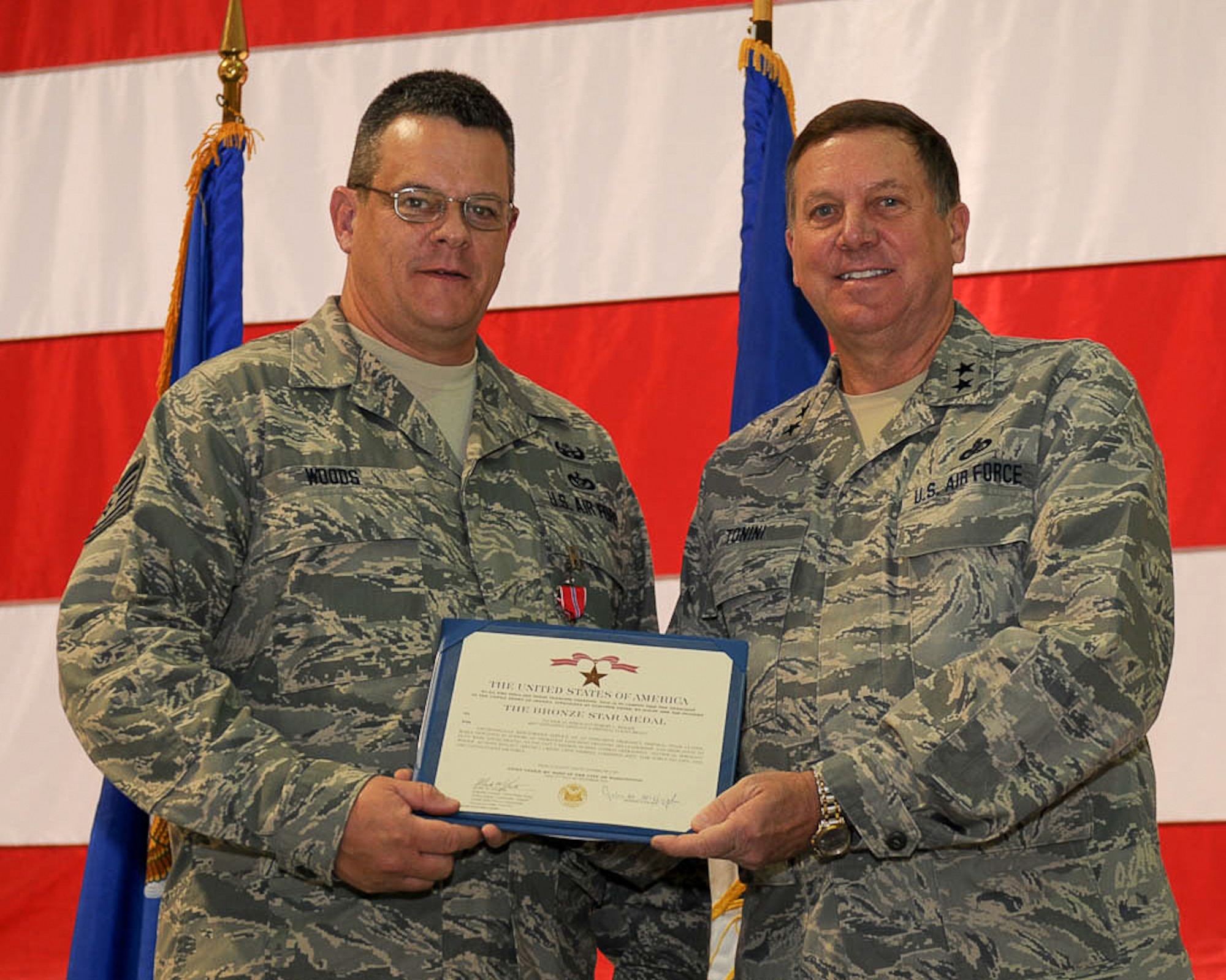 Kentucky???s adjutant general, Maj. Gen. Edward W. Tonini (right), presents Tech. Sgt. Robert L. Woods of the 123rd Civil Engineer Squadron with a Bronze Star Medal during a ceremony held Nov. 20, 2011, at the Kentucky Air National Guard Base in Louisville, Ky.  Meuser earned the combat decoration for his exceptionally meritorious service while deployed to Afghanistan as an explosive ordnance disposal team leader supporting Operation Enduring Freedom. (U.S. Air Force photo by Tech. Sgt. Dennis Flora)