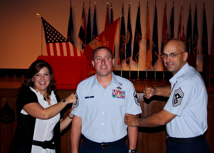 Senior Master Sgt. Bruce Tims, of the 919th Operations Support Squadron, gets his stripes tacked on by his wife, Melissa Tims, and Chief Master Sgt. Michael Klausutis, the 919th Special Operations Wing command chief, after his graduation from the Marine Corps Staff NCO Academy, Advanced Course at Camp Lejeune, N.C. Oct. 14.  Tims was promoted via the promotion enhancement program while attending the course.  Tims was the first Air Force reservist to graduate the Marine leadership course.  (Courtesy photo)