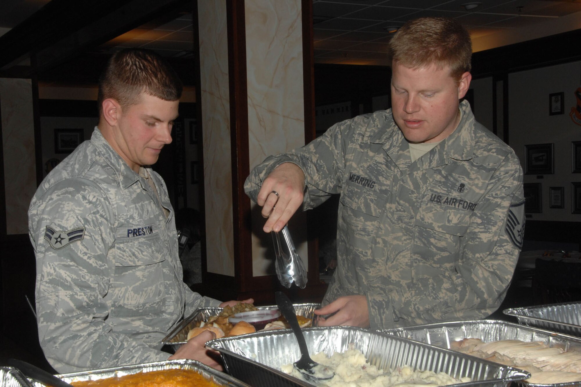 HANSCOM AIR FORCE BASE, Mass. – Master Sgt. Ray Merring (right), Airman and Family Readiness Center, serves up a platter of Thanksgiving-themed food to Airman 1st Class Scott Preston, 66th Security Forces Squadron, during the Single Airmen Dinner at the Minuteman Commons Nov. 18. Formerly the Dorm Dinner, the new program is open to any single Airman, E-4 and below, and will be held in various locations on a quarterly basis. (U.S. Air Force photo by Linda LaBonte Britt)