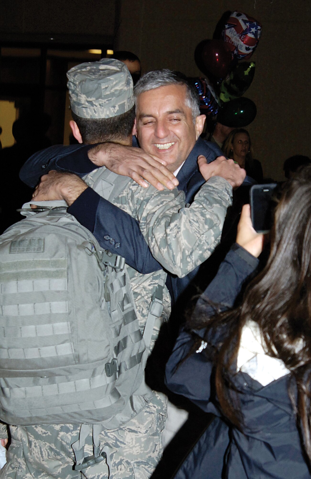 Ebrahim Namazi embraces his son, 1st Lt. Shahin Namazi when the 552nd Airman returned to Tinker Nov. 16 following a six-month Southwest Asia deployment in support of operations in Afghanistan. Mr. Namazi, his wife and daughter flew from their New York home earlier that day and waited hours for Lieutenant Namazi. They held signs and anxiously scanned faces as returning Airmen trickled from the plane in the cold and dark. Spotting him, they shrieked with joy and bounded toward him. After a brief evening celebrating his return and also his birthday, the family would fly home to New York early the next morning.  (Air Force photo by Margo Wright)