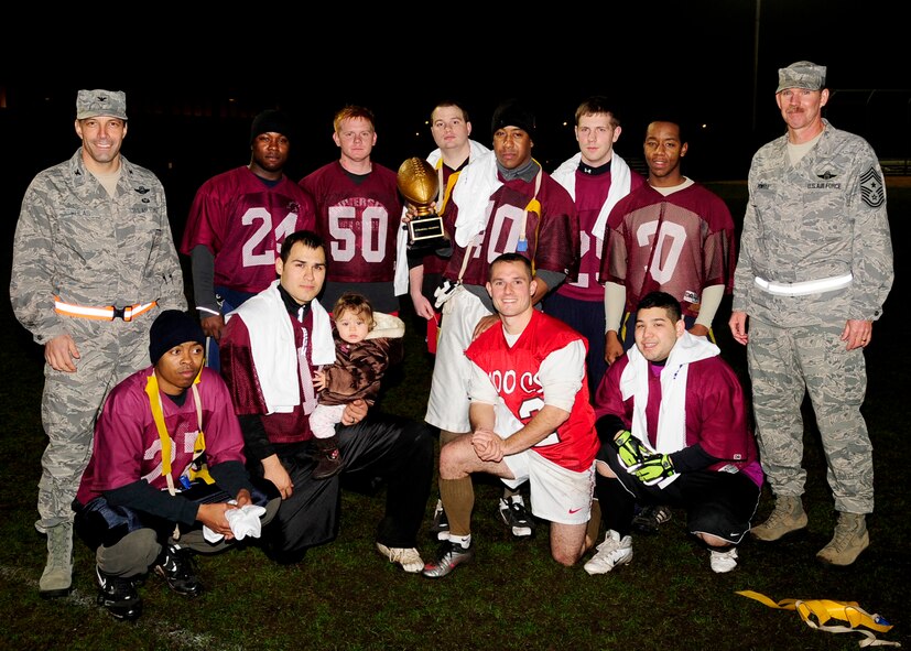 RAF MILDENHALL, England – Col. Christopher Kulas, 100th Air Refueling Wing commander, and Chief Master Sgt. Christopher Powell, 100th ARW command chief, pose with the 100th Communications Squadron football team after the team won the championship intramural football game here Nov. 23, 2011. The 100th CS team played against the 100th Maintenance Squadron and won the game 8-0. (U.S. Air Force photo/Senior Airman Ethan Morgan)                   