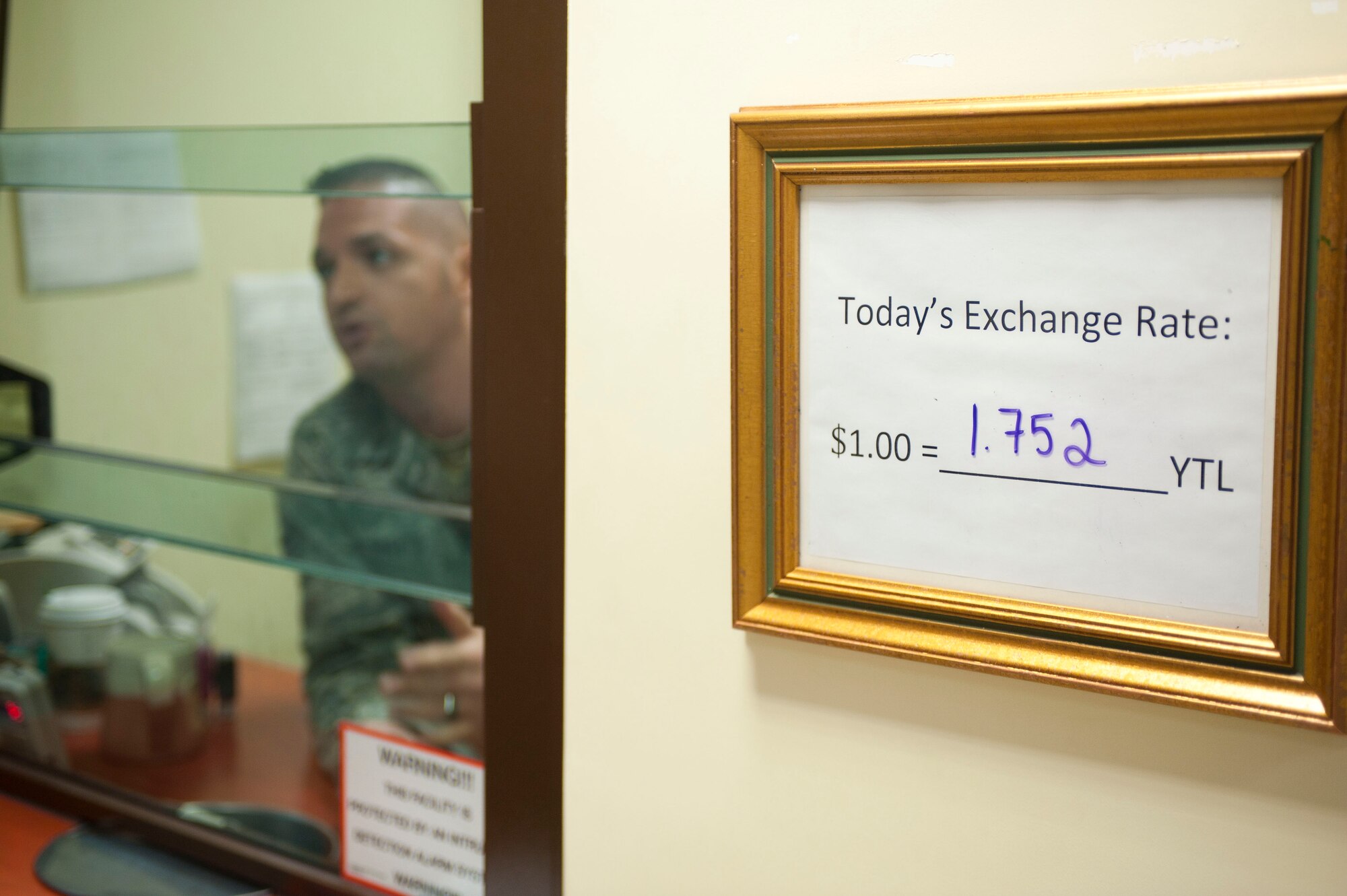 Staff Sgt. Clay DeRogatis, 39th Comptroller Squadron, speaks with a customer Oct. 27, 2011, at Incirlik Air Base, Turkey. The cash cage on Incirlik is the only one on a U.S. Air Forces in Europe installation and offers base residents a place to cash checks. (U.S. Air Force photo by Senior Airman Clayton Lenhardt/Released)